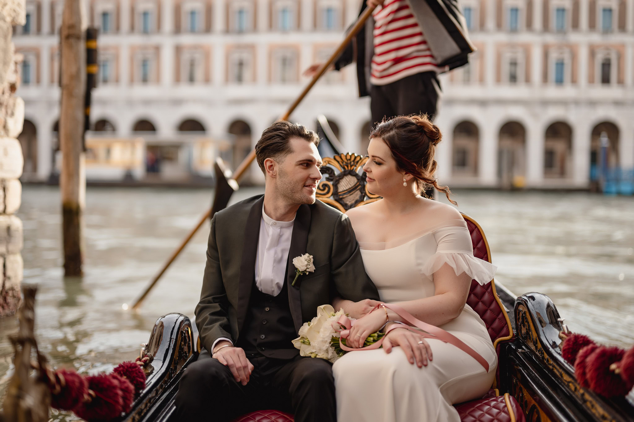 Couple seated in a gondola at Ca’ Sagredo Palace in Venice during an elopement.