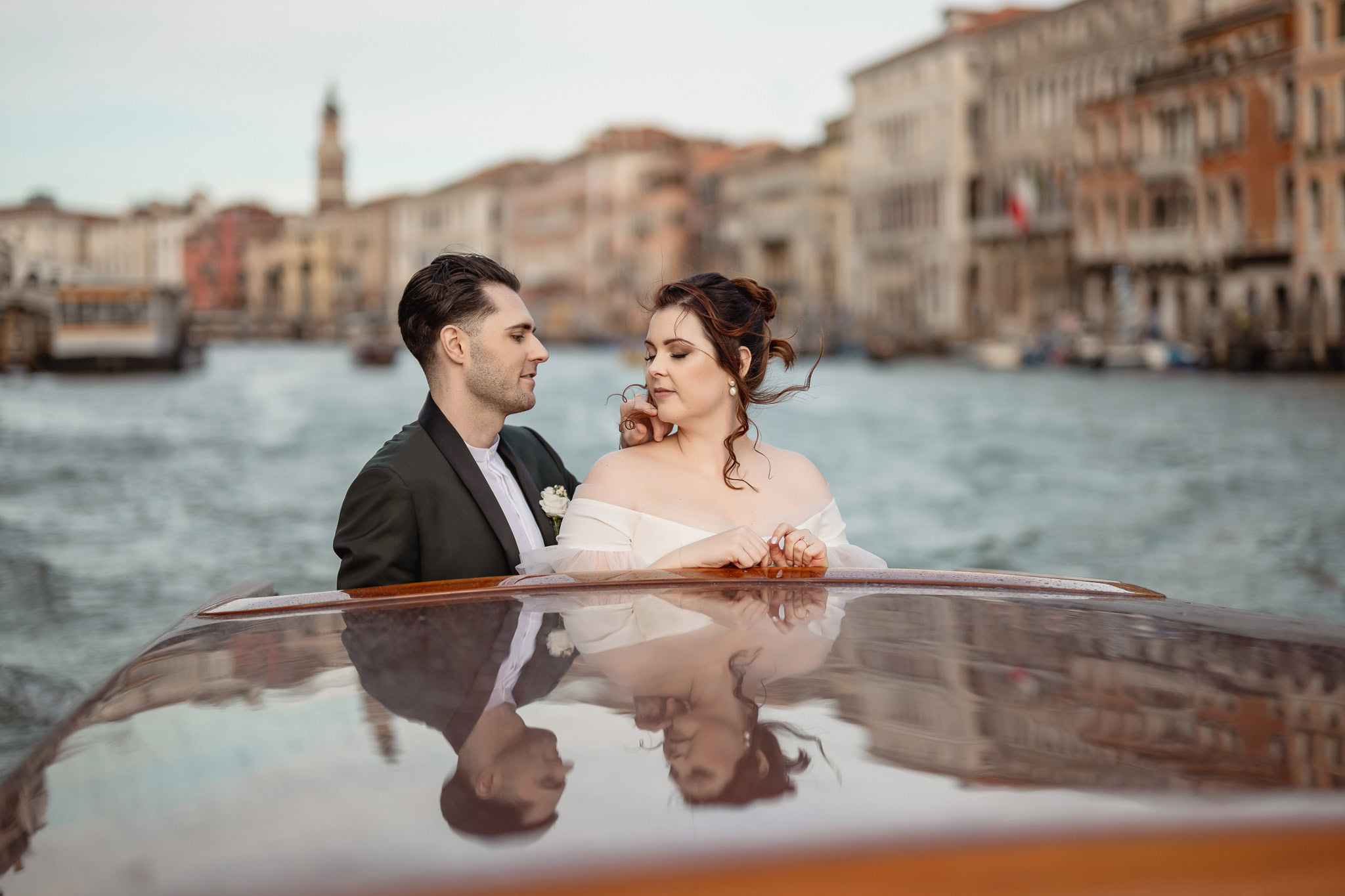 Elegant couple on a boat at Ca’ Sagredo Palace in Venice during an elopement.