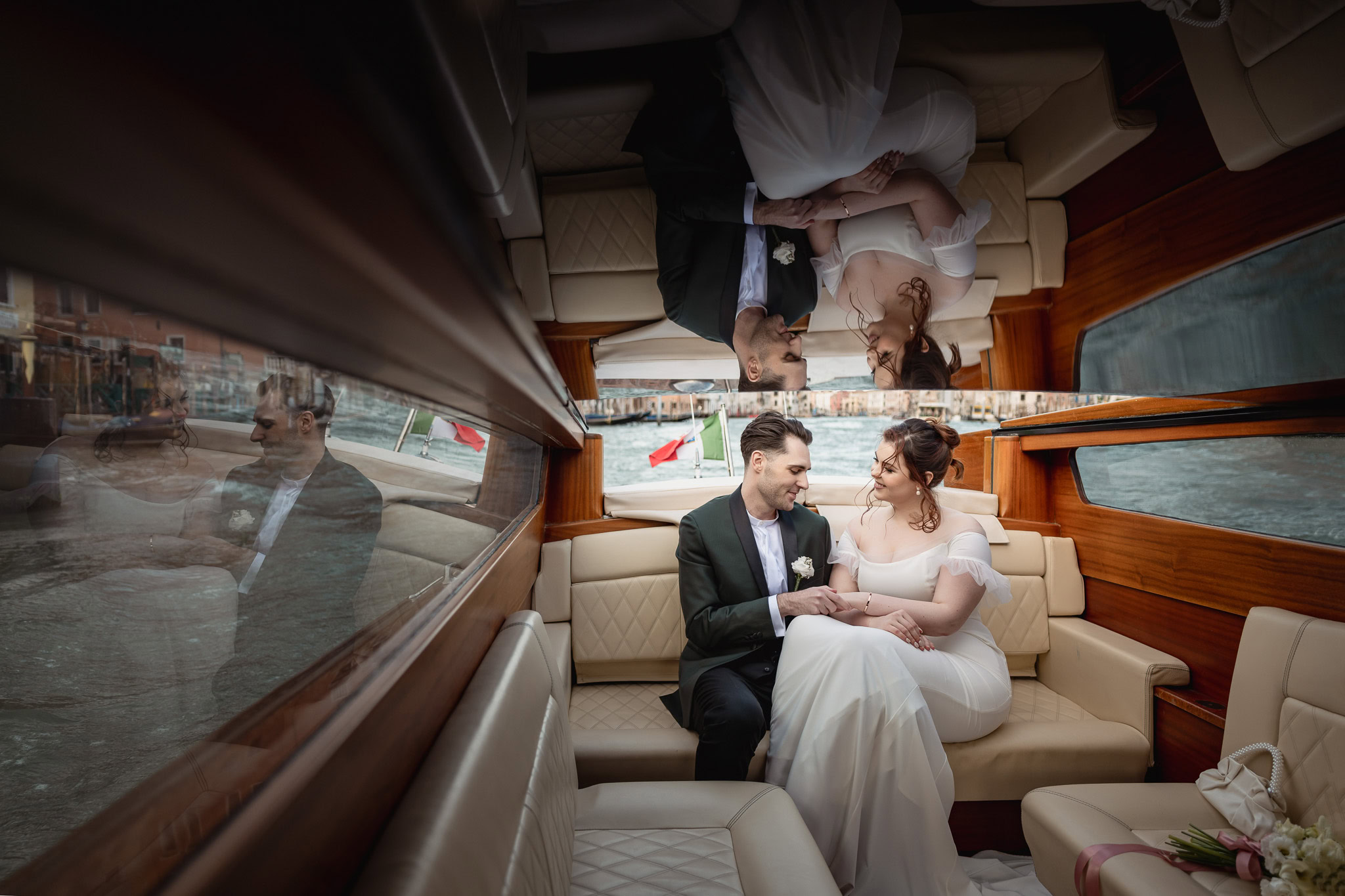 Couple sitting inside Ca’ Sagredo Palace boat, holding hands and gazing at each other.