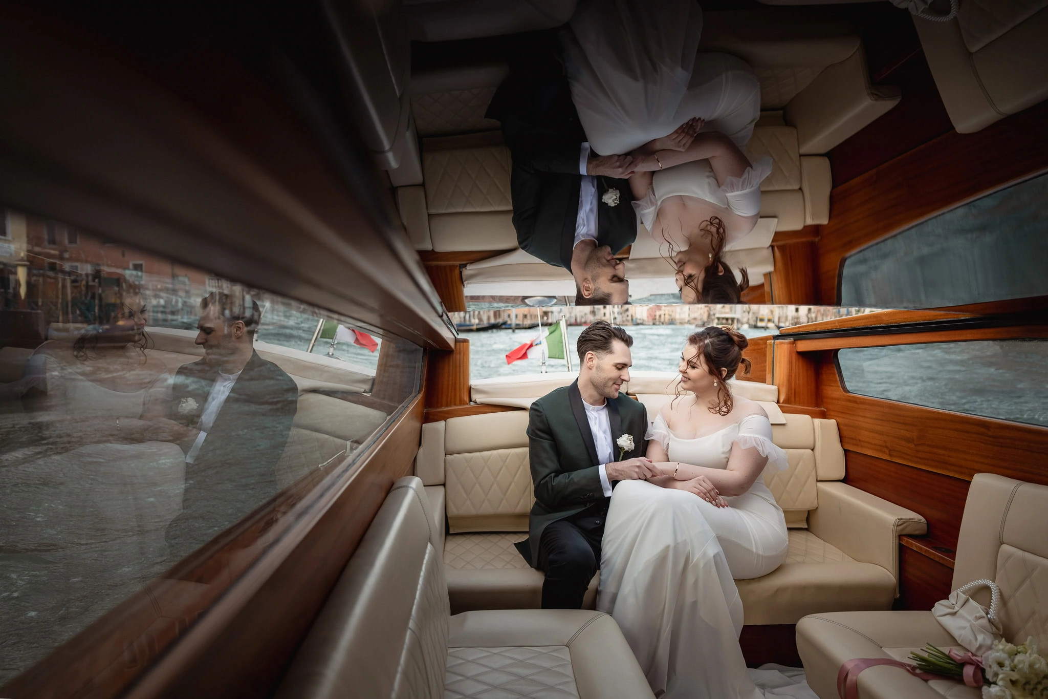 Couple sitting inside Ca’ Sagredo Palace boat, holding hands and gazing at each other.