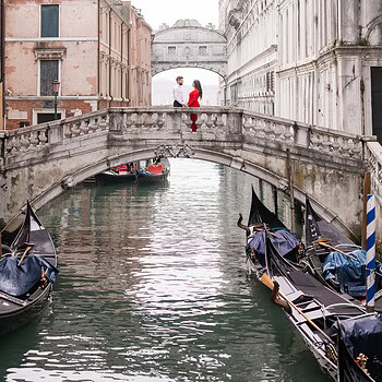 Romantic couple during a quiet moment on a Venice canal bridge.