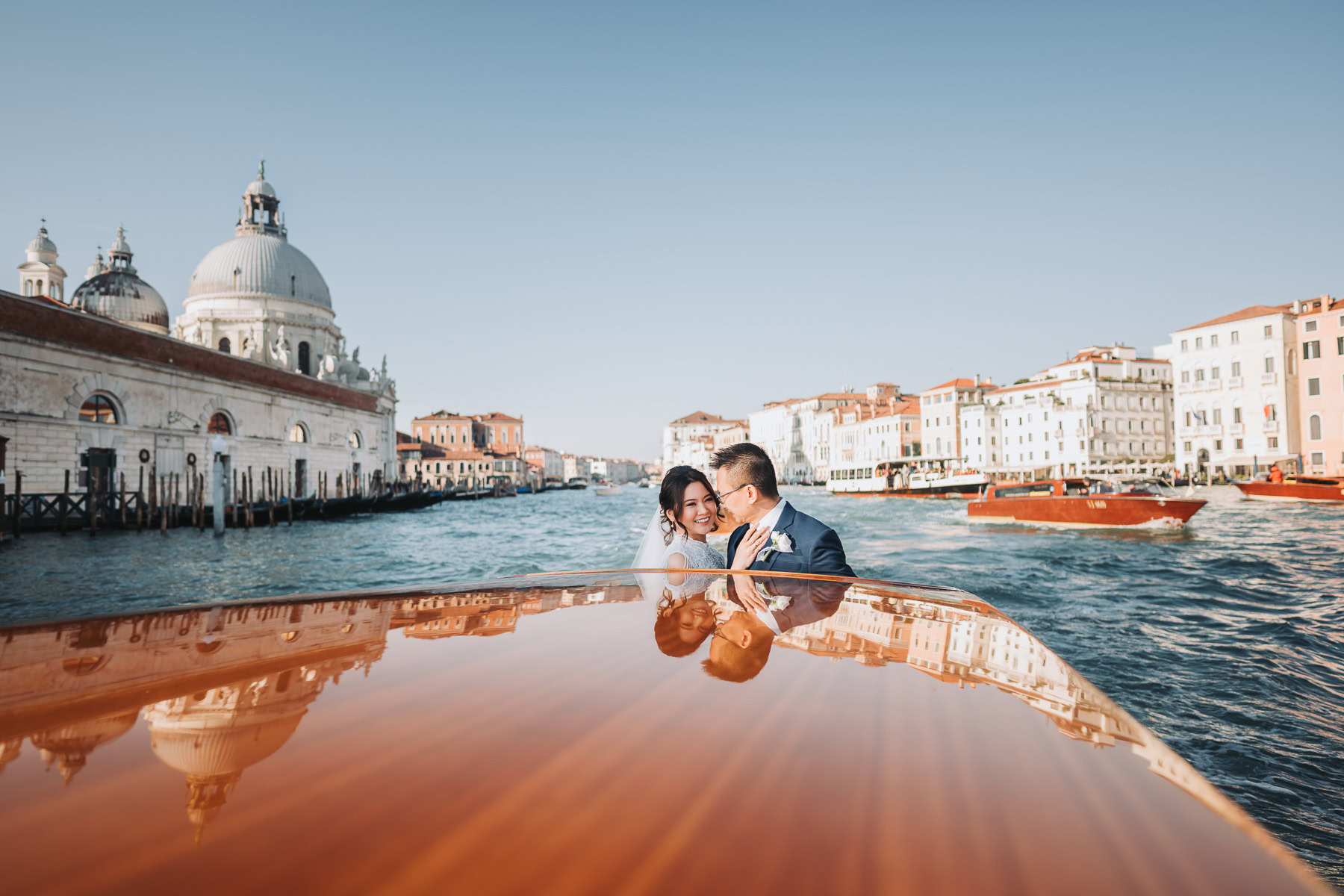 Couple enjoying a moment on a boat near Scuola Grande dei Carmini in Venice.