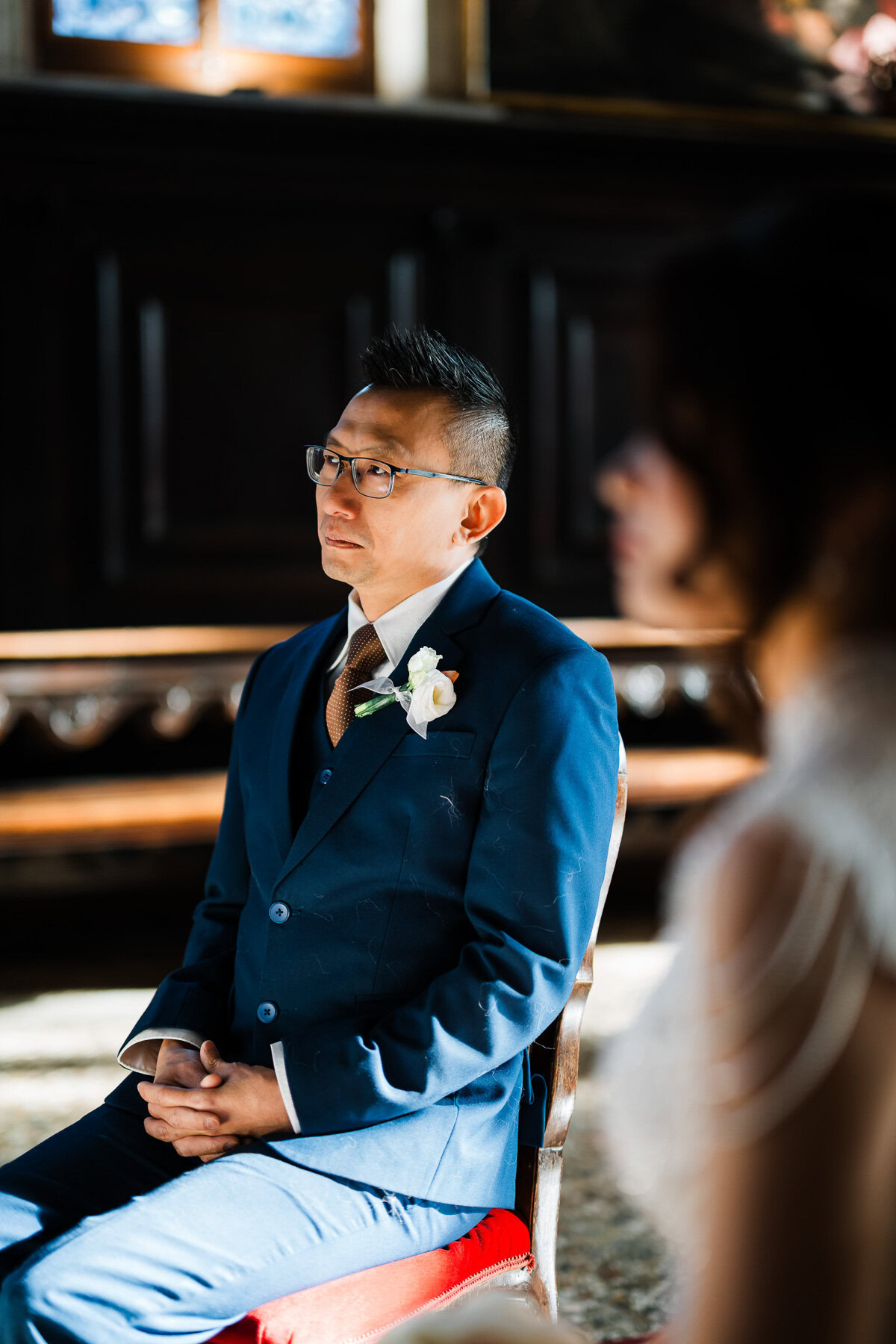 A man in a blue suit sitting in front of a piano at Scuola Grande dei Carmini Venice.