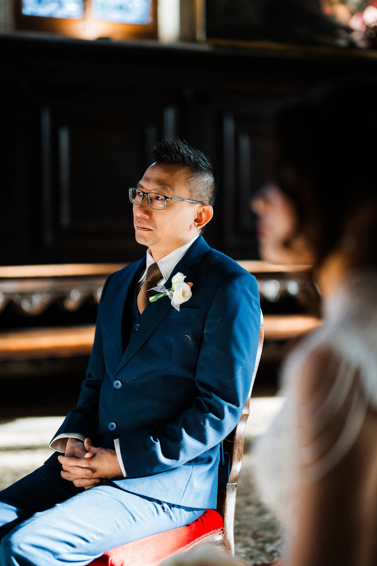 A man in a blue suit sitting in front of a piano at Scuola Grande dei Carmini Venice.