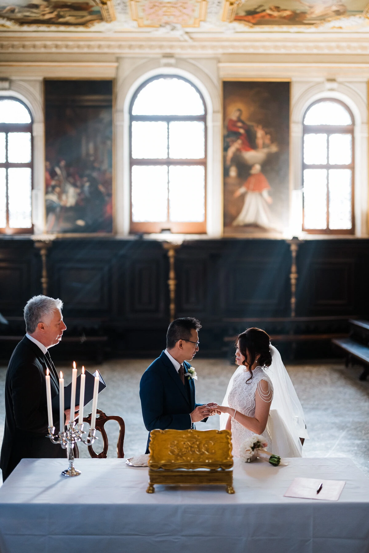 A couple exchanging vows inside the Scuola Grande dei Carmini in Venice.