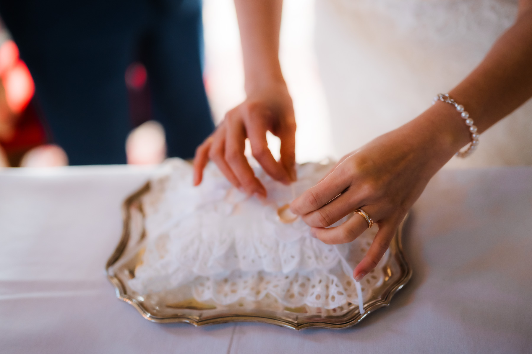 Hands placing a ring on a tray at Scuola Grande dei Carmini during an elopement moment.