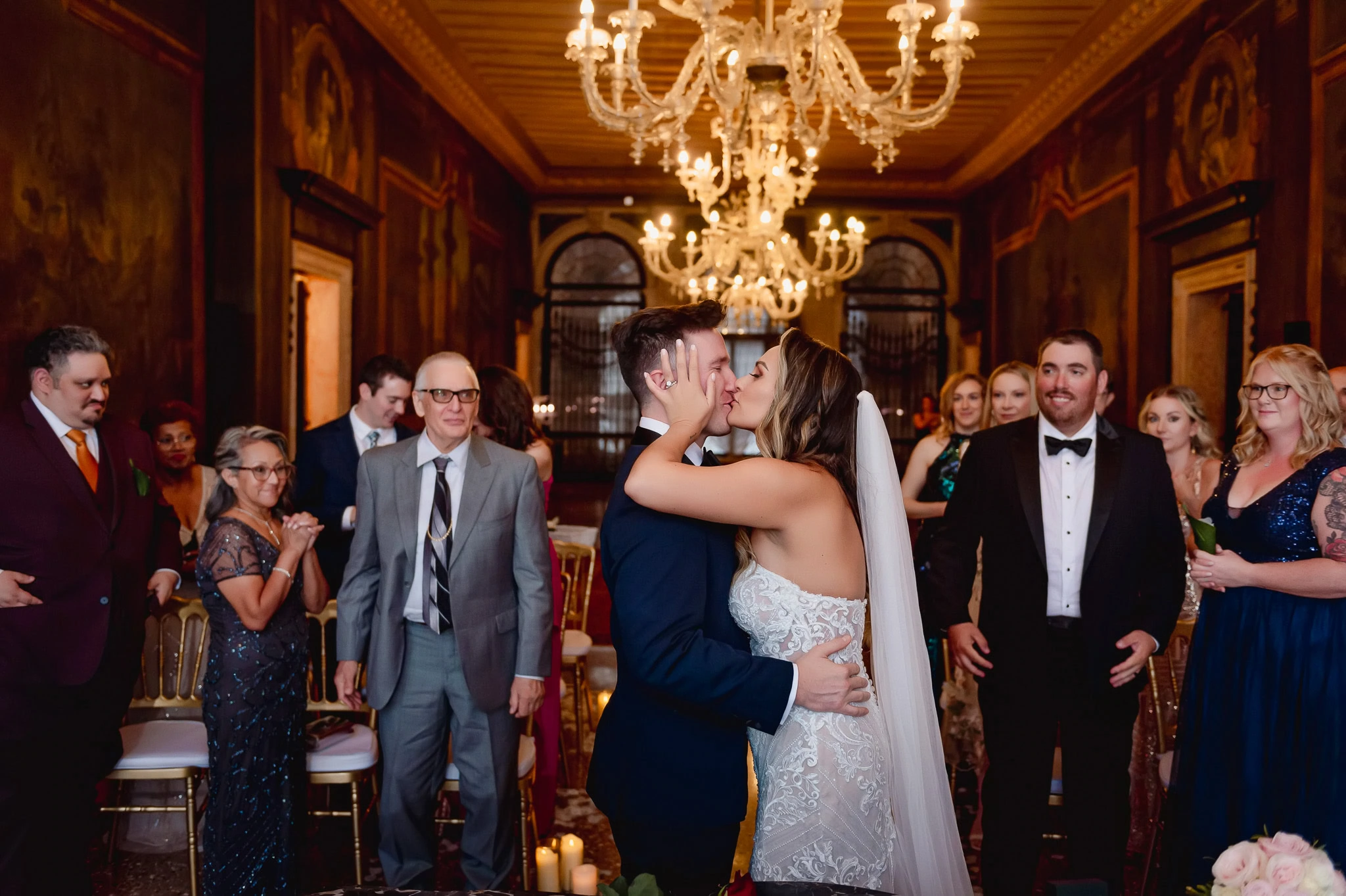 Bride and groom kiss during wedding ceremony in Venetian Ca' Sagredo palace.