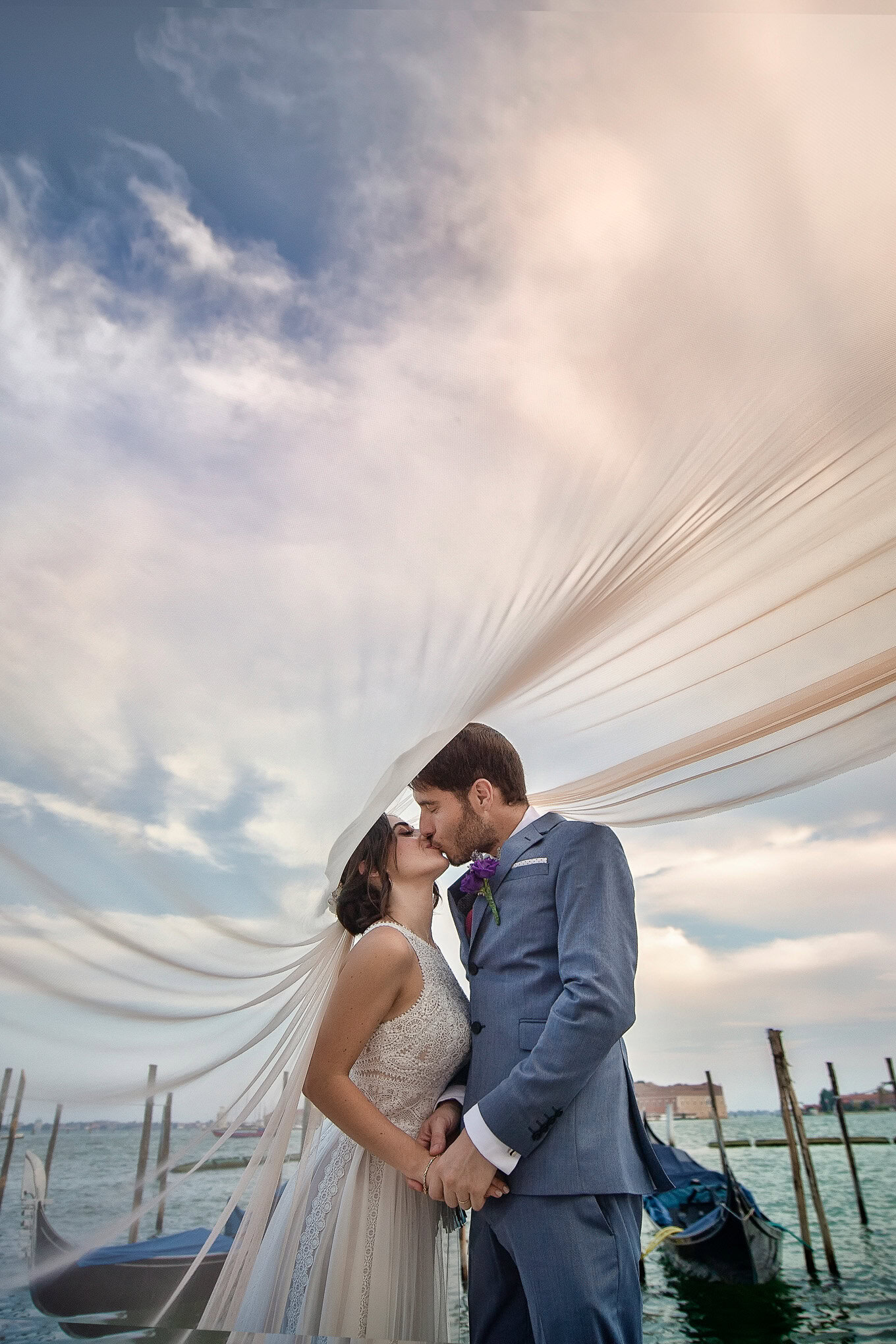 A lush, intimate couple shares a tender moment beneath a flowing canopy on a Venetian dock, bathed in soft, natural ligh.