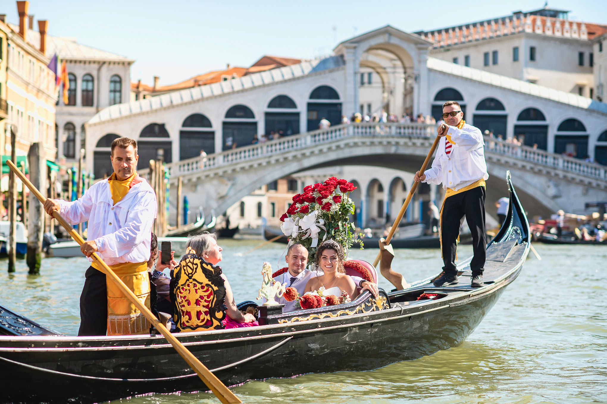 Intimate couple sharing a romantic gondola ride through Venice's historic canals at sunset, surrounded by warm light and.
