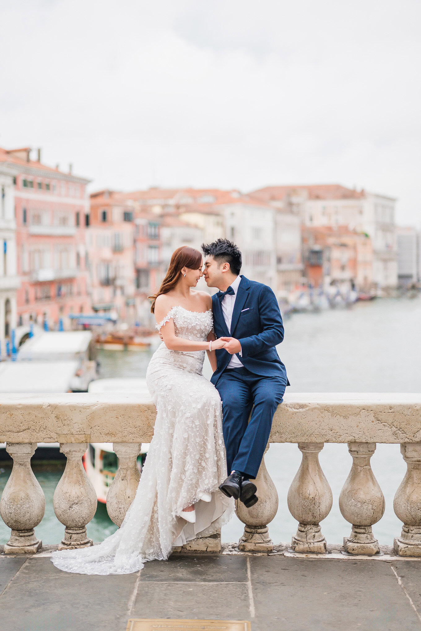 A couple sharing an intimate moment on a historic waterfront promenade, soft natural light highlight.