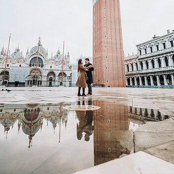 Romantic couple embracing at Piazza San Marco during acqua alta at sunrise, Venice.