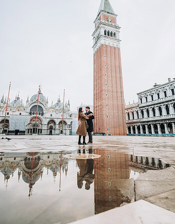Romantic couple embracing at Piazza San Marco during acqua alta at sunrise, Venice.