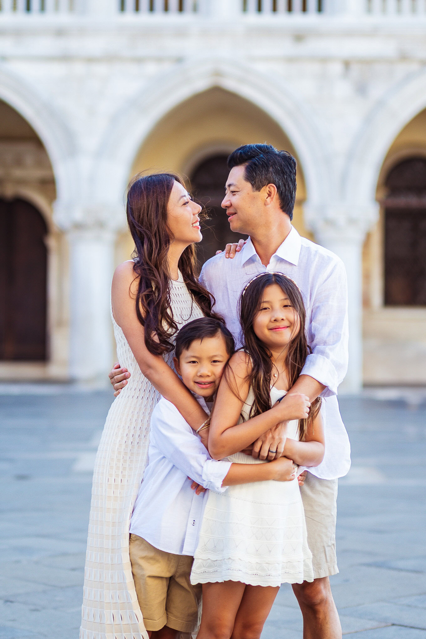Family enjoying a sunny day together in Venice, with historic architecture in the background and warm natural light illu.
