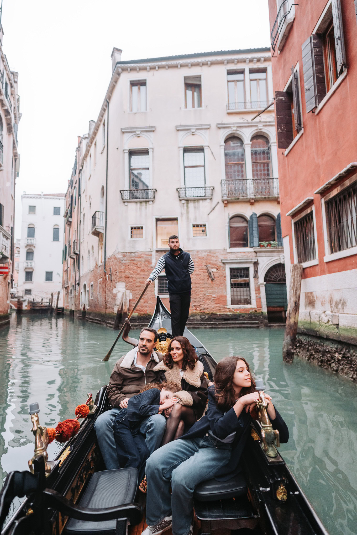 An accessible scene of a family enjoying a gondola ride through Venice's historic canals, with sunlight illuminating the.