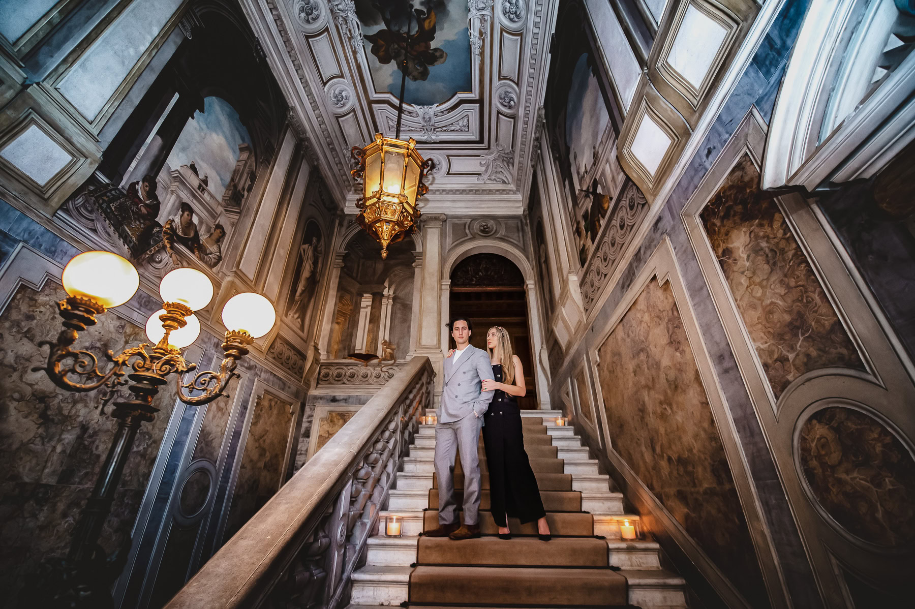 Elegant honeymoon couple at Aman Venice inside a historic palace staircase.