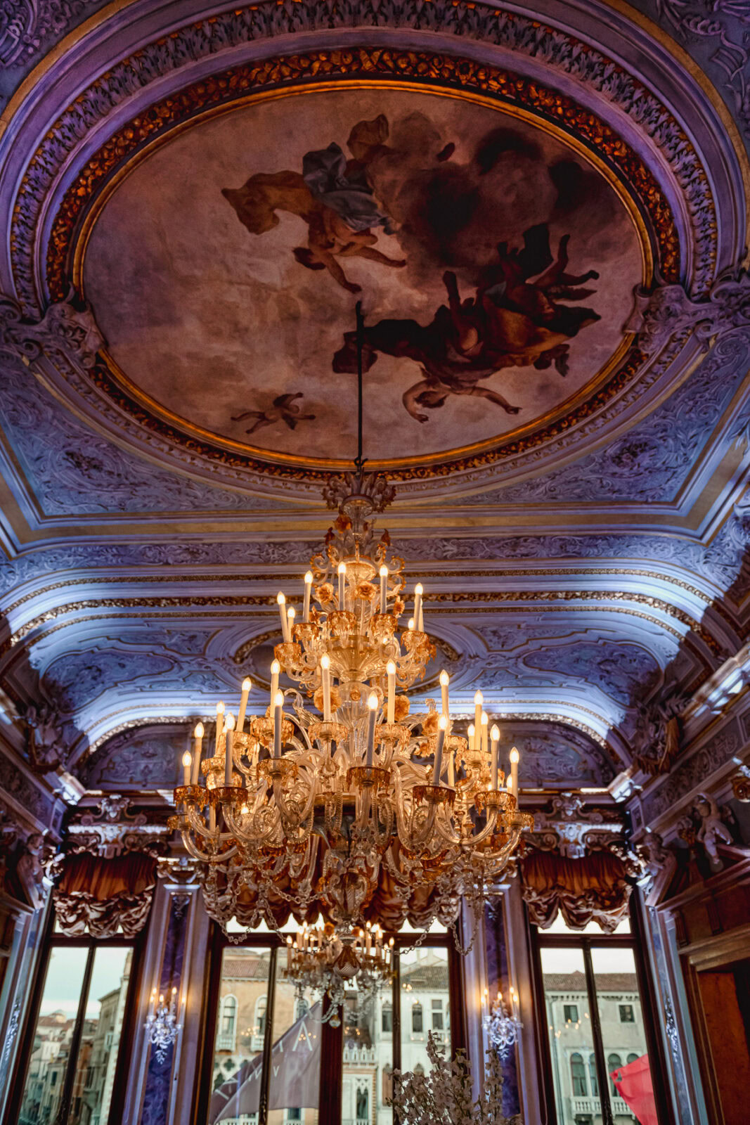 Elegant interior of Aman Venice with ornate ceiling and grand chandelier.