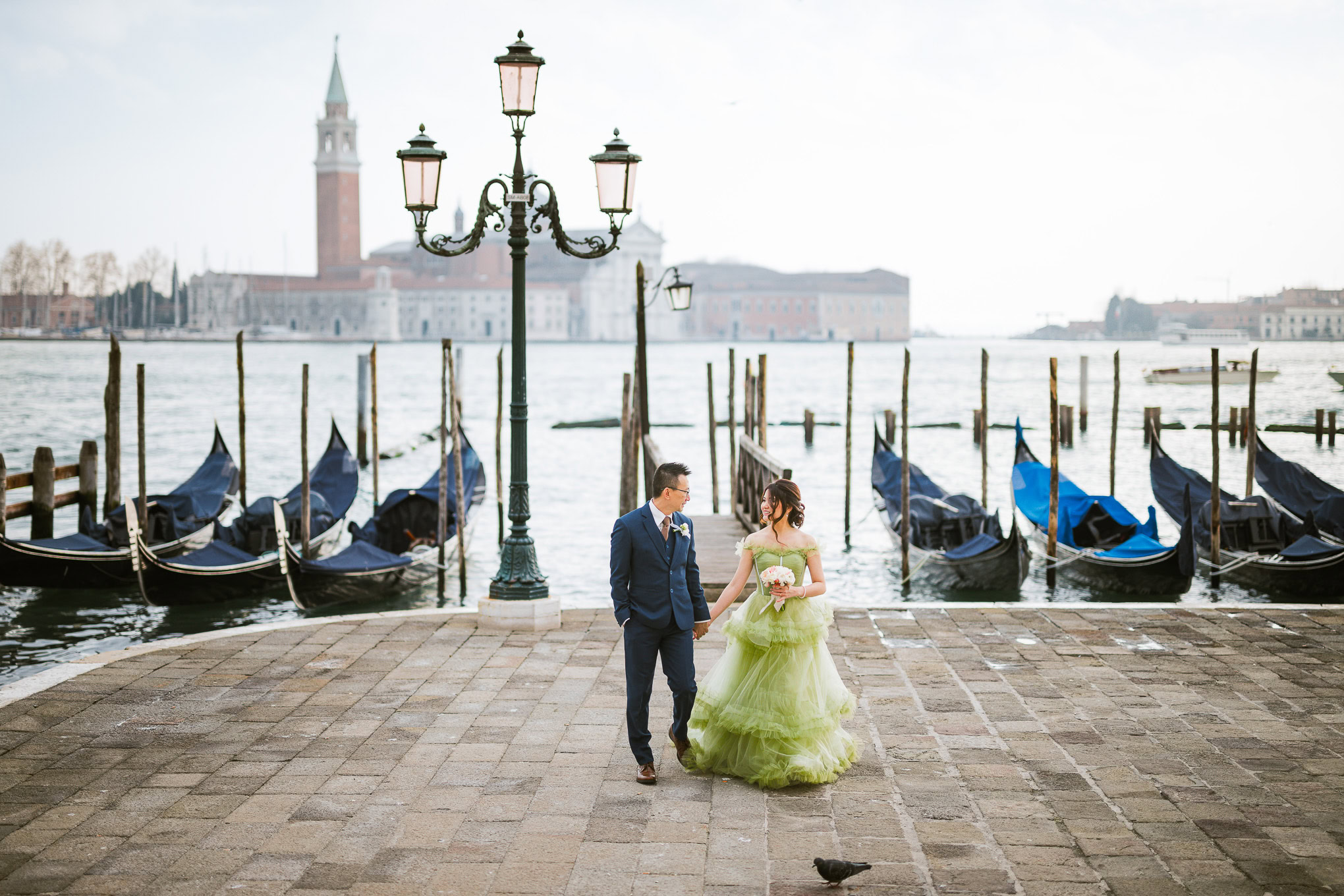 Romantic couple strolling along Venice waterfront at sunset, surrounded by gondolas and historic architecture, in a drea.