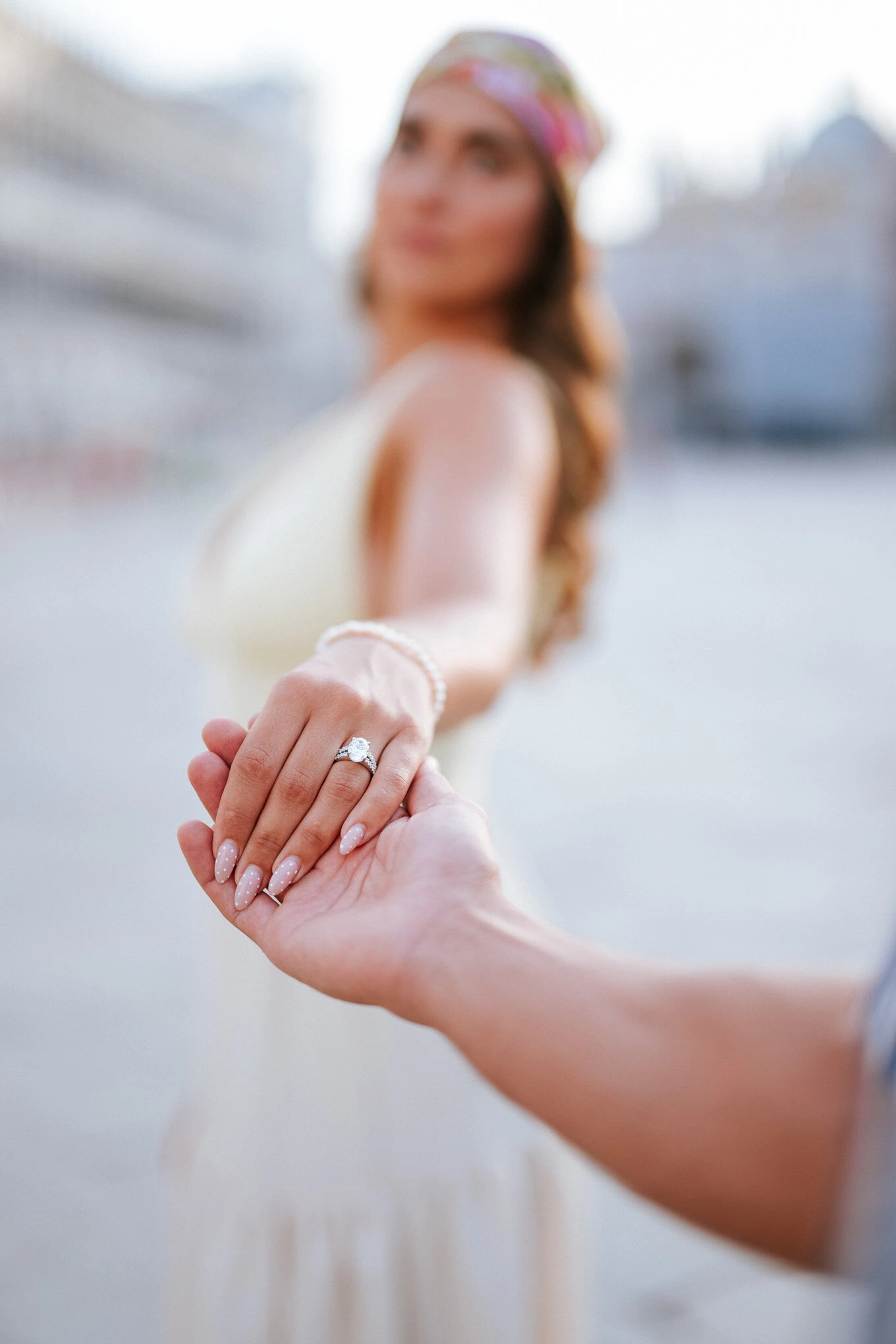 A romantic proposal in Venice capturing the moment of a couple holding hands with an engagement ring.