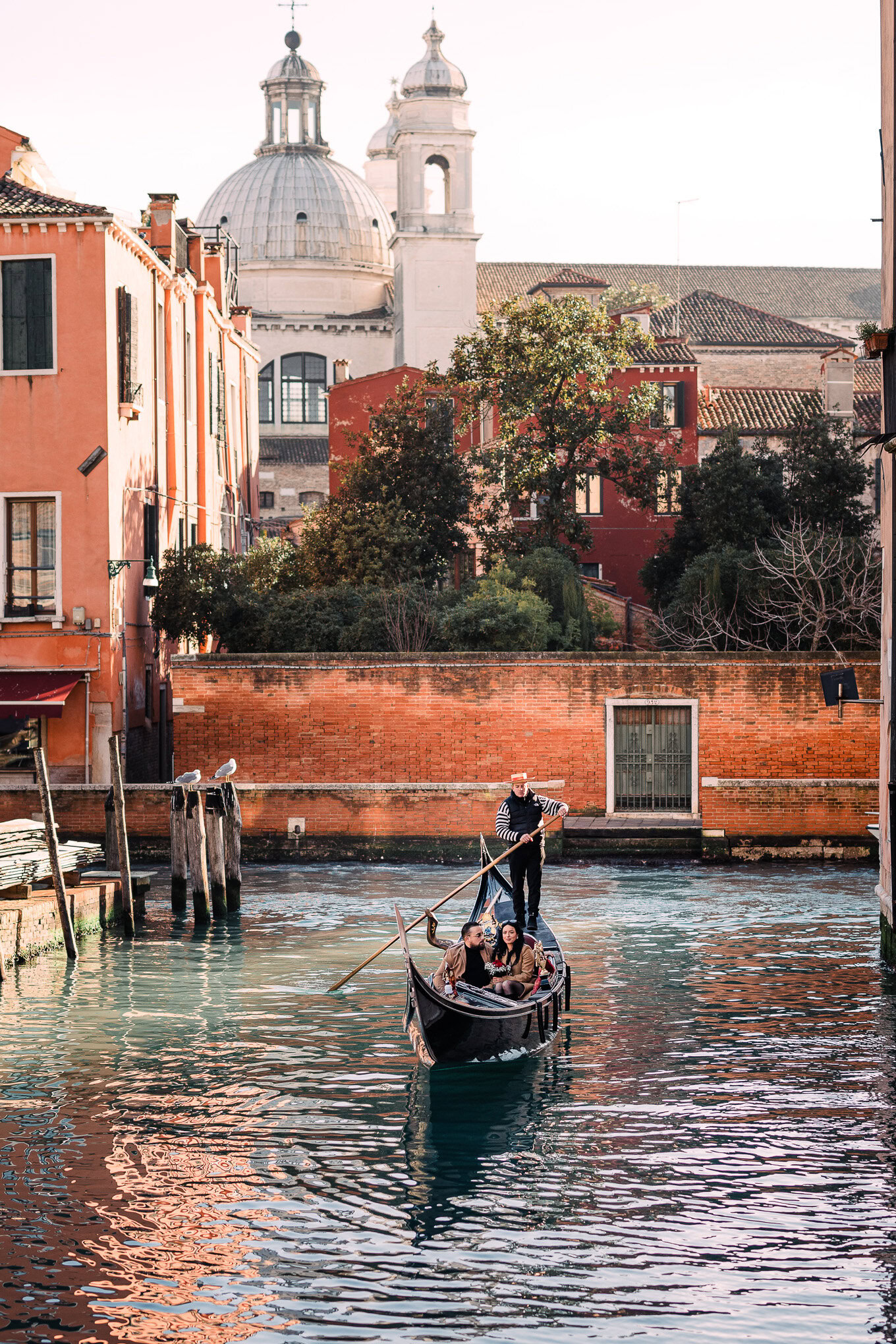 A couple shares a heartfelt proposal moment on a gondola gliding through Venice's canals.