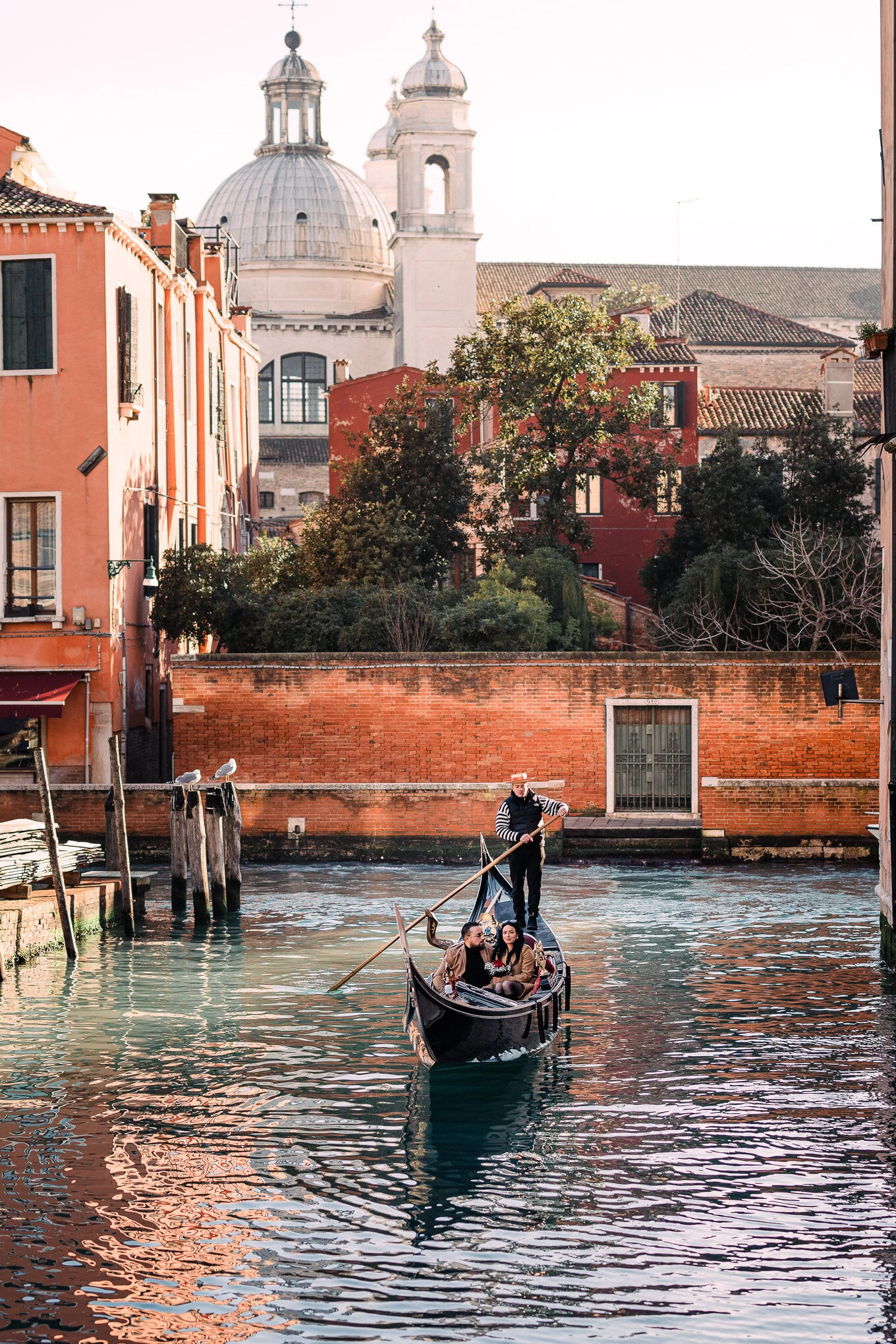 A couple shares a heartfelt proposal moment on a gondola gliding through Venice's canals.