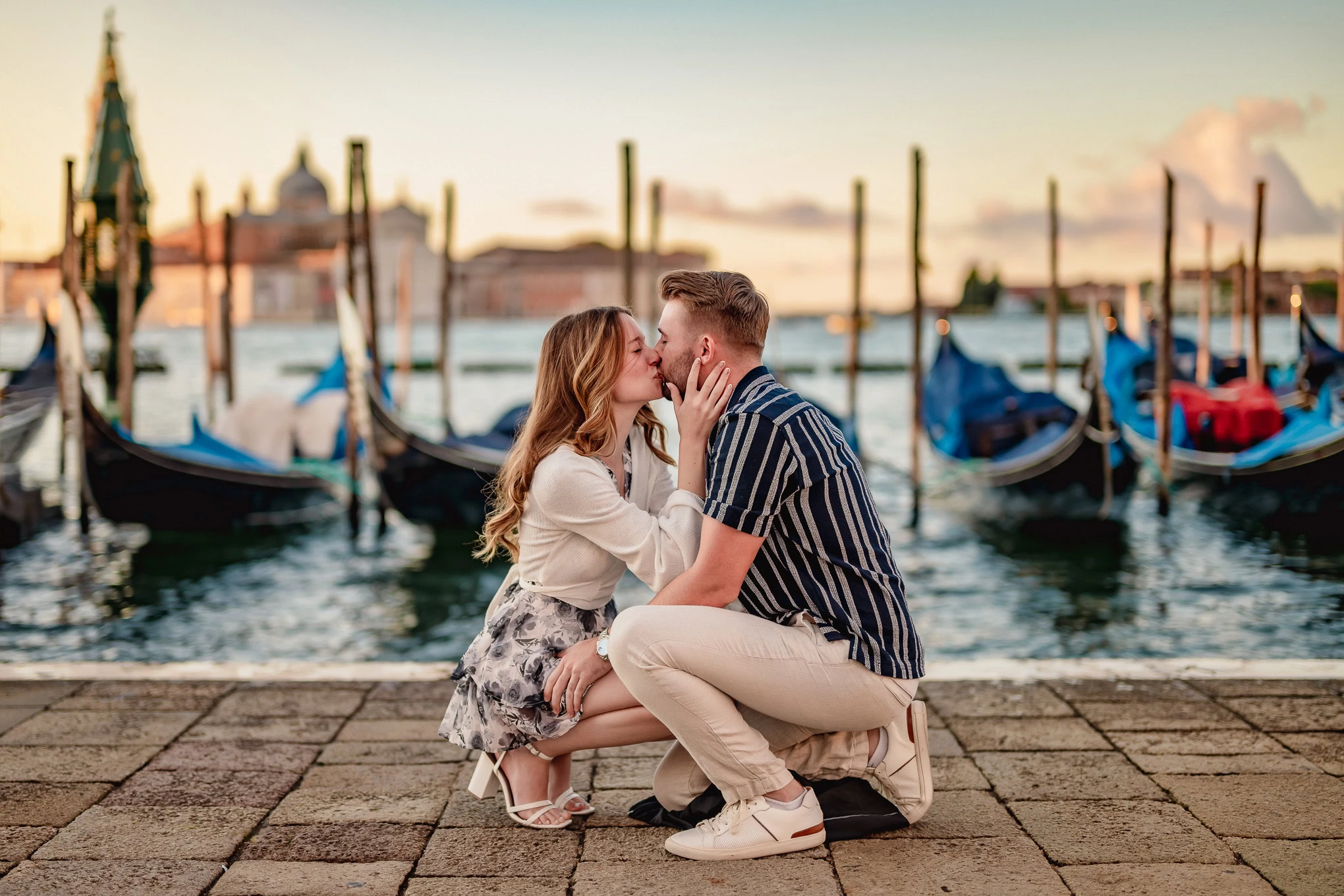 A couple shares a heartfelt proposal moment by the Venice canal, capturing raw emotion and love in a scenic setting.