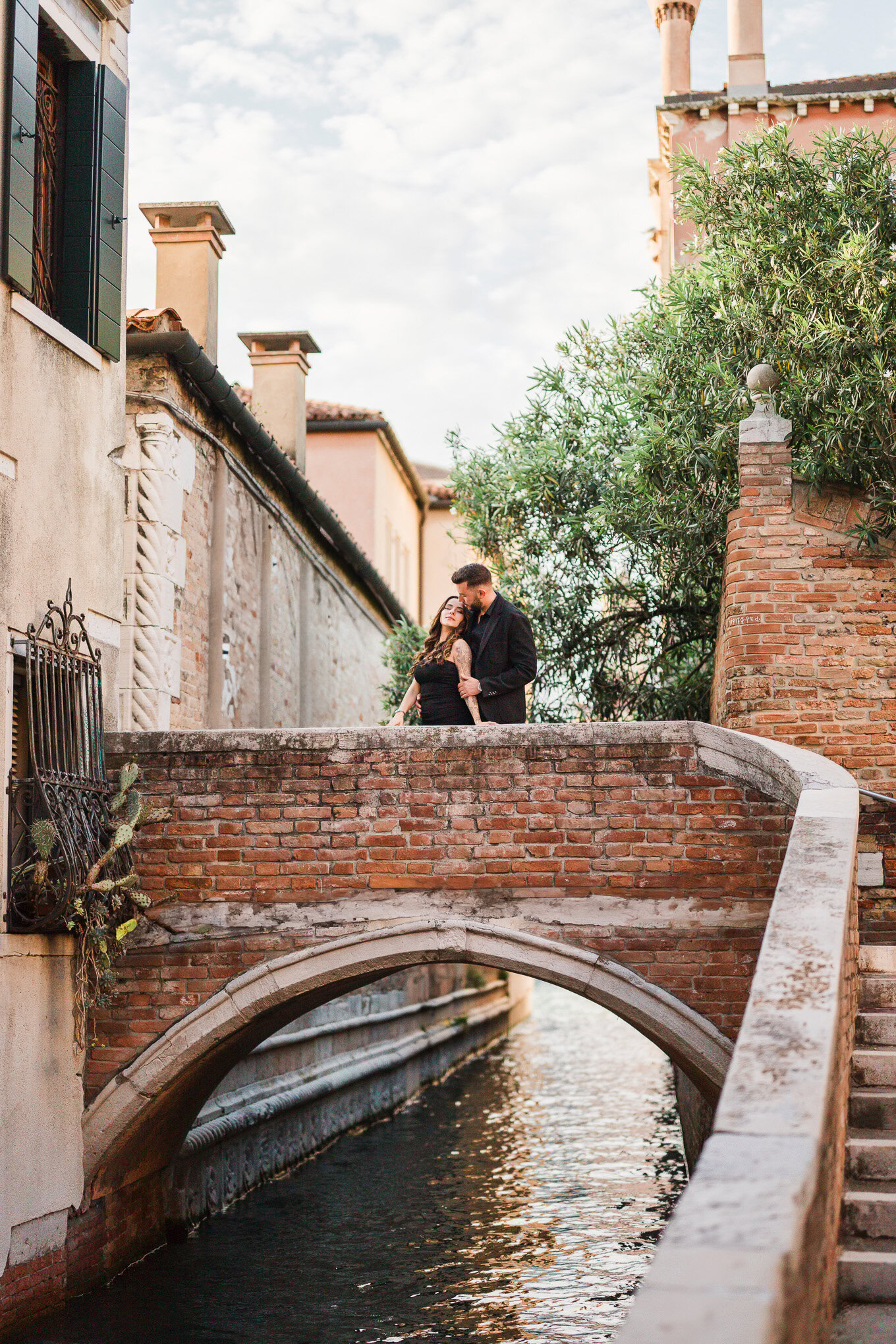 A person proposes marriage to their partner on a charming Venice canal bridge, capturing a heartfelt, emotional moment.