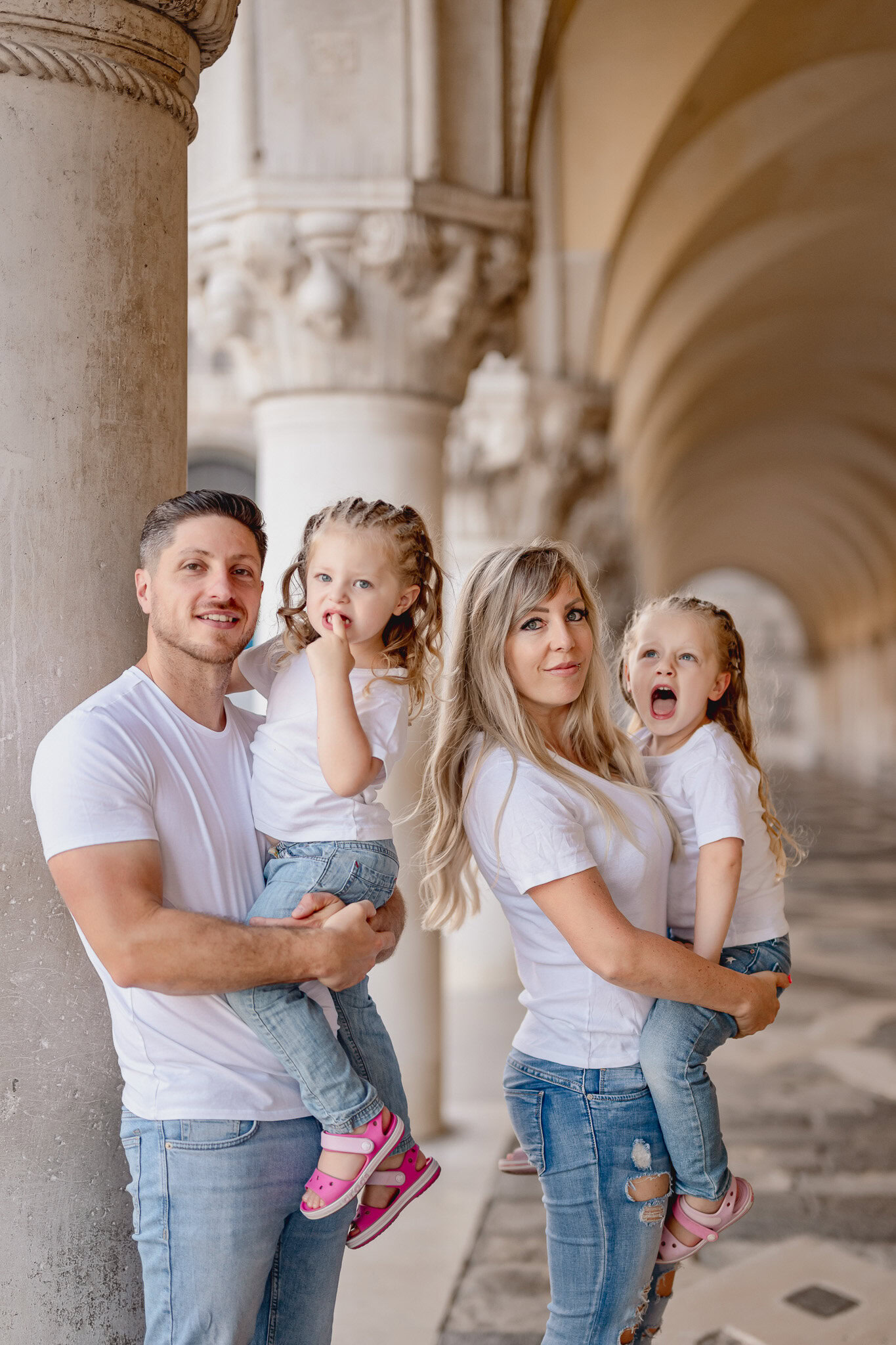 People standing near columns in San Marco Square, Venice, with arches and historic architecture in t.