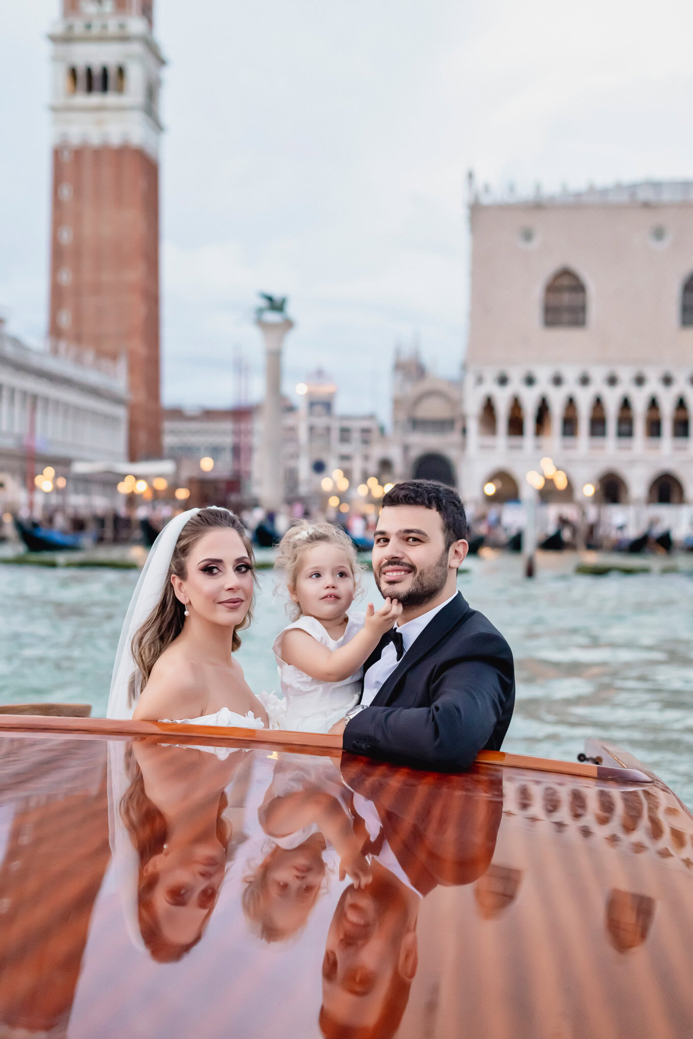 A beautiful family portrait on a gondola in Venice, with historic architecture and soft daylight creating a romantic atm.