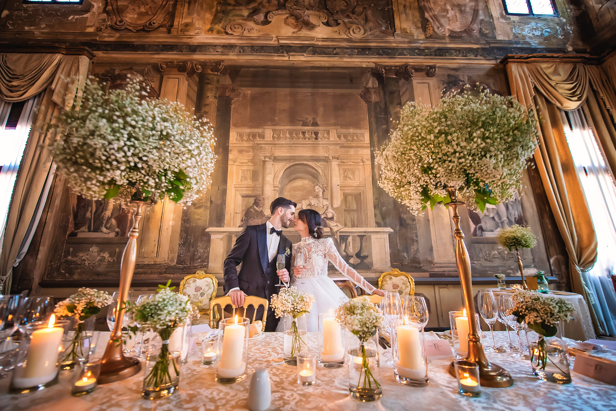 Elegant newlyweds share a tender moment at a beautifully decorated Venetian wedding reception with warm candlelight and.