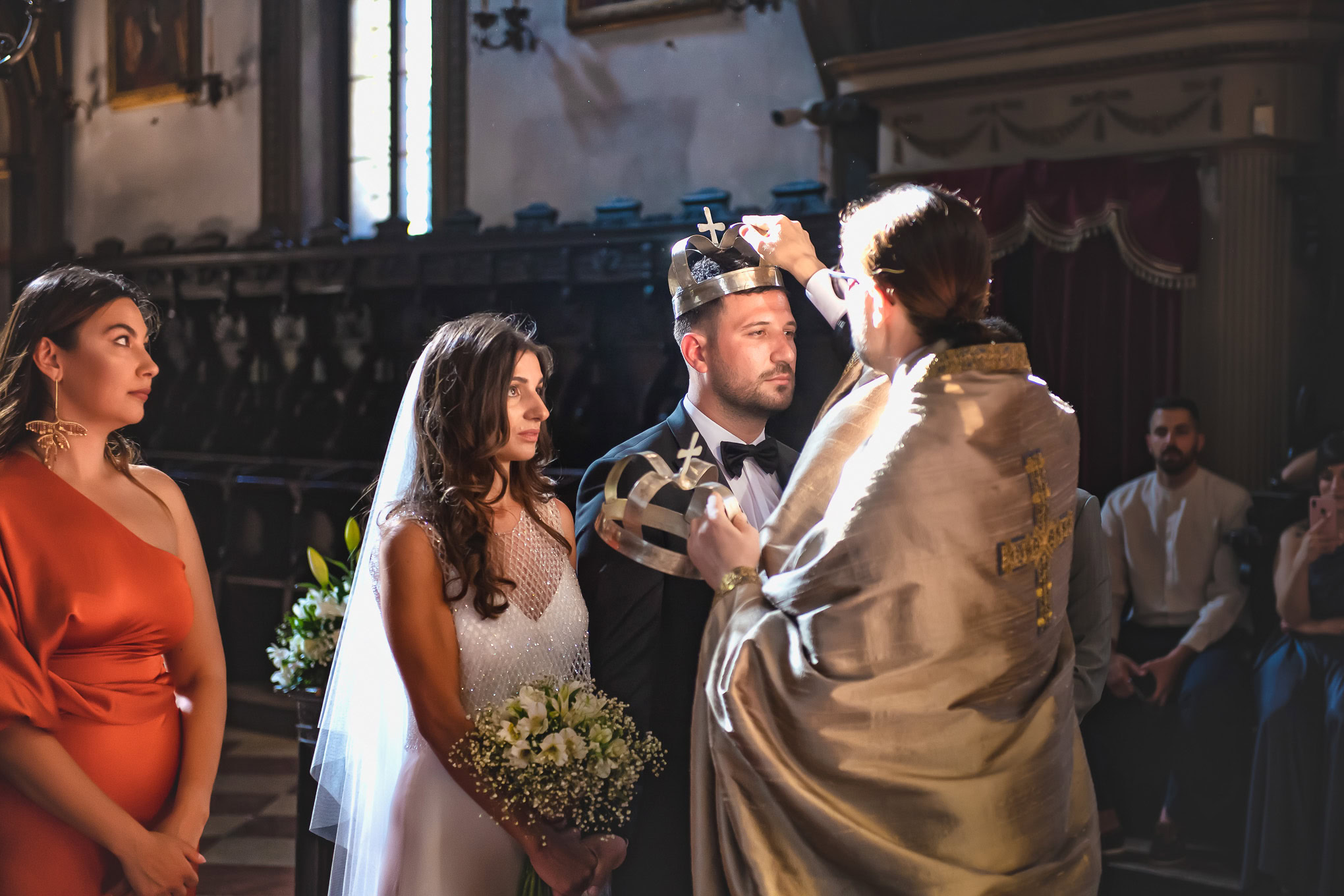 A beautiful wedding moment in Venice capturing the bride and groom during the ceremony with an officiant, illuminated by.
