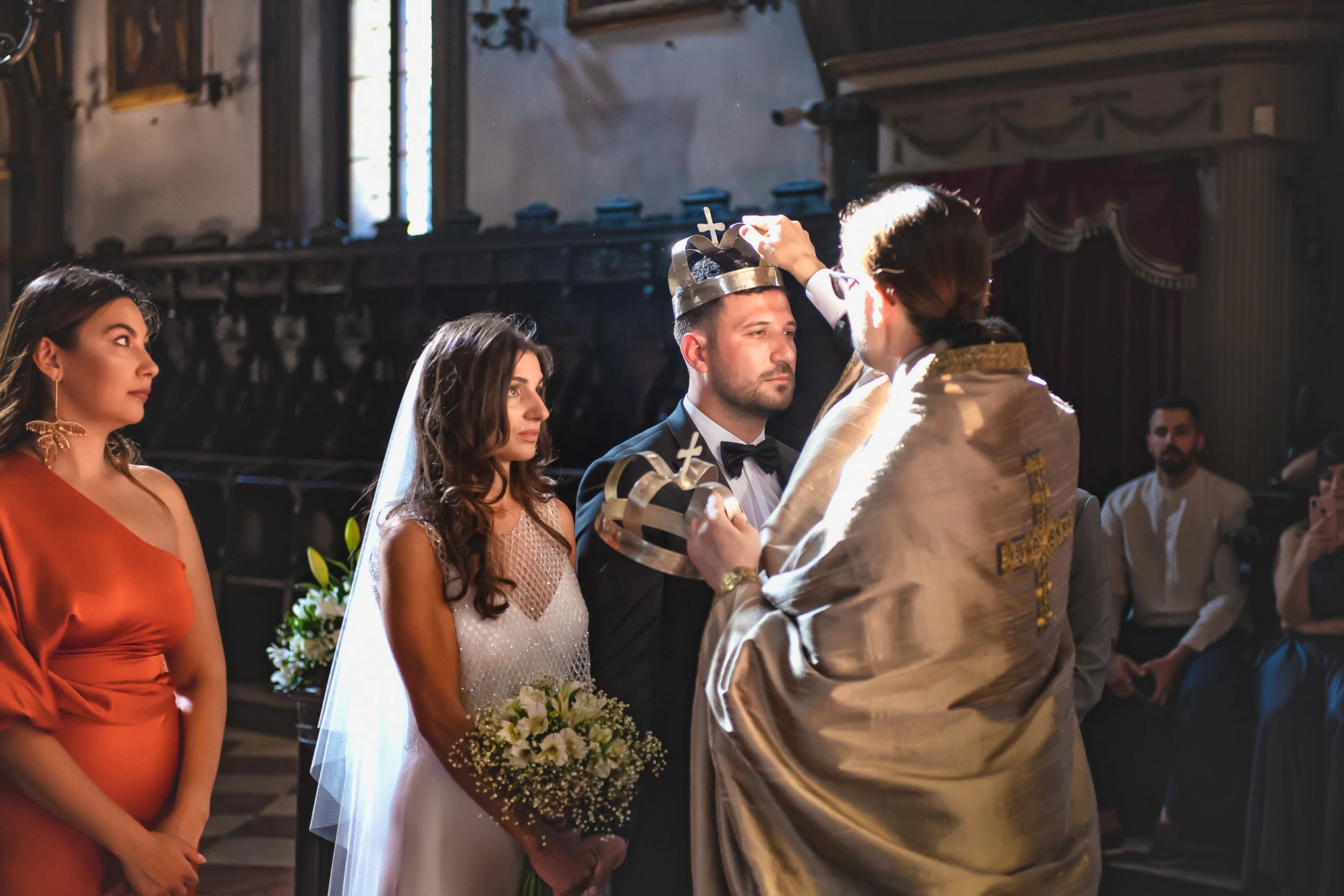 A beautiful wedding moment in Venice capturing the bride and groom during the ceremony with an officiant, illuminated by.