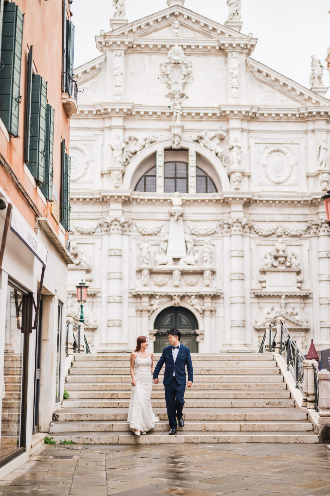 Couple on steps of ornate baroque church facade in Venice