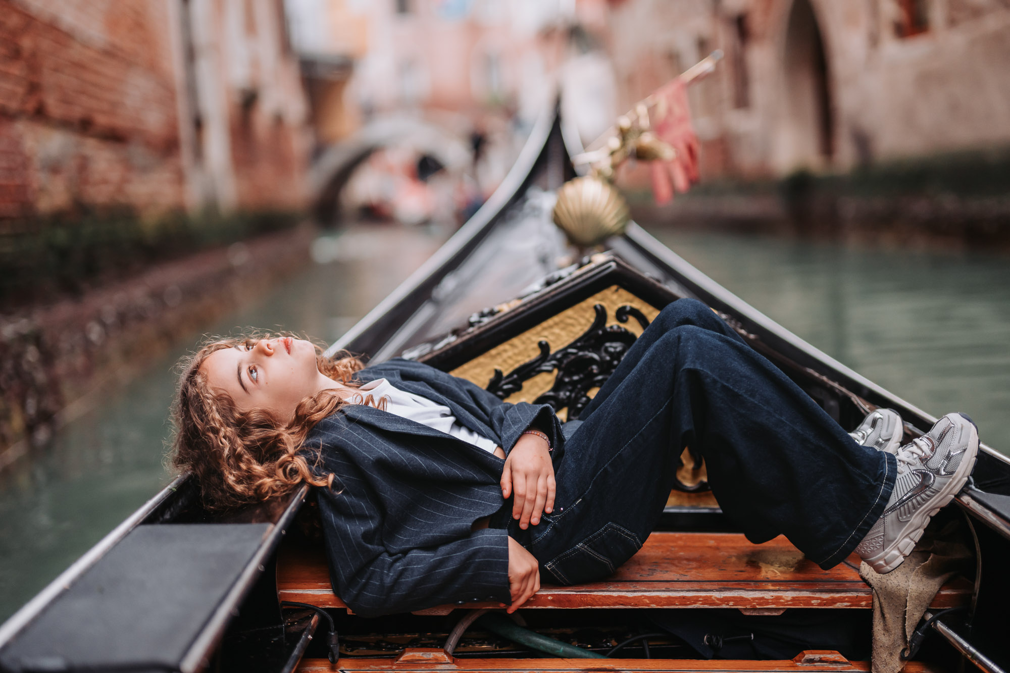 Gondola in Venice with a child smiling and relaxing, family enjoying a ride during late afternoon light.