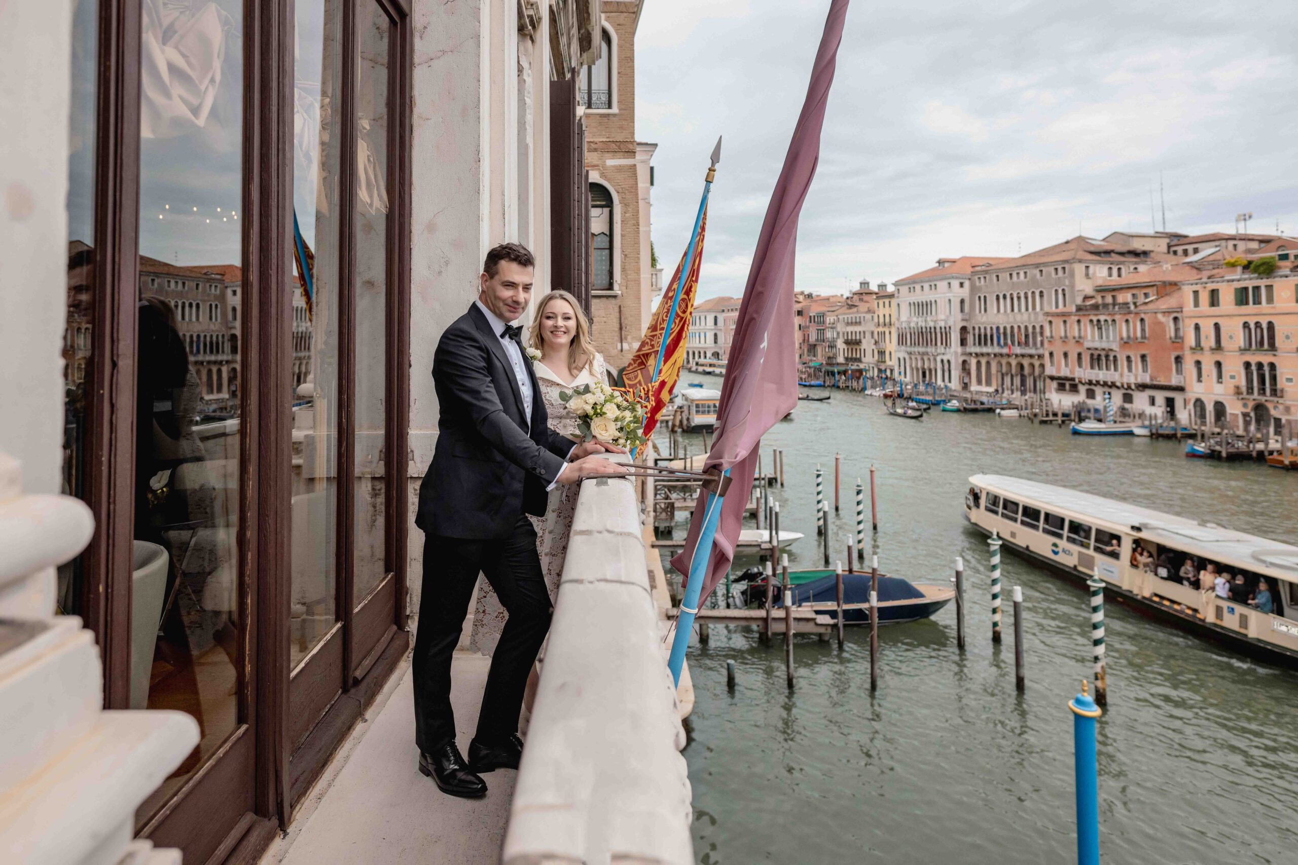 Venice elopement photographer capturing a couple on a balcony overlooking the canal during a wedding in Venice.
