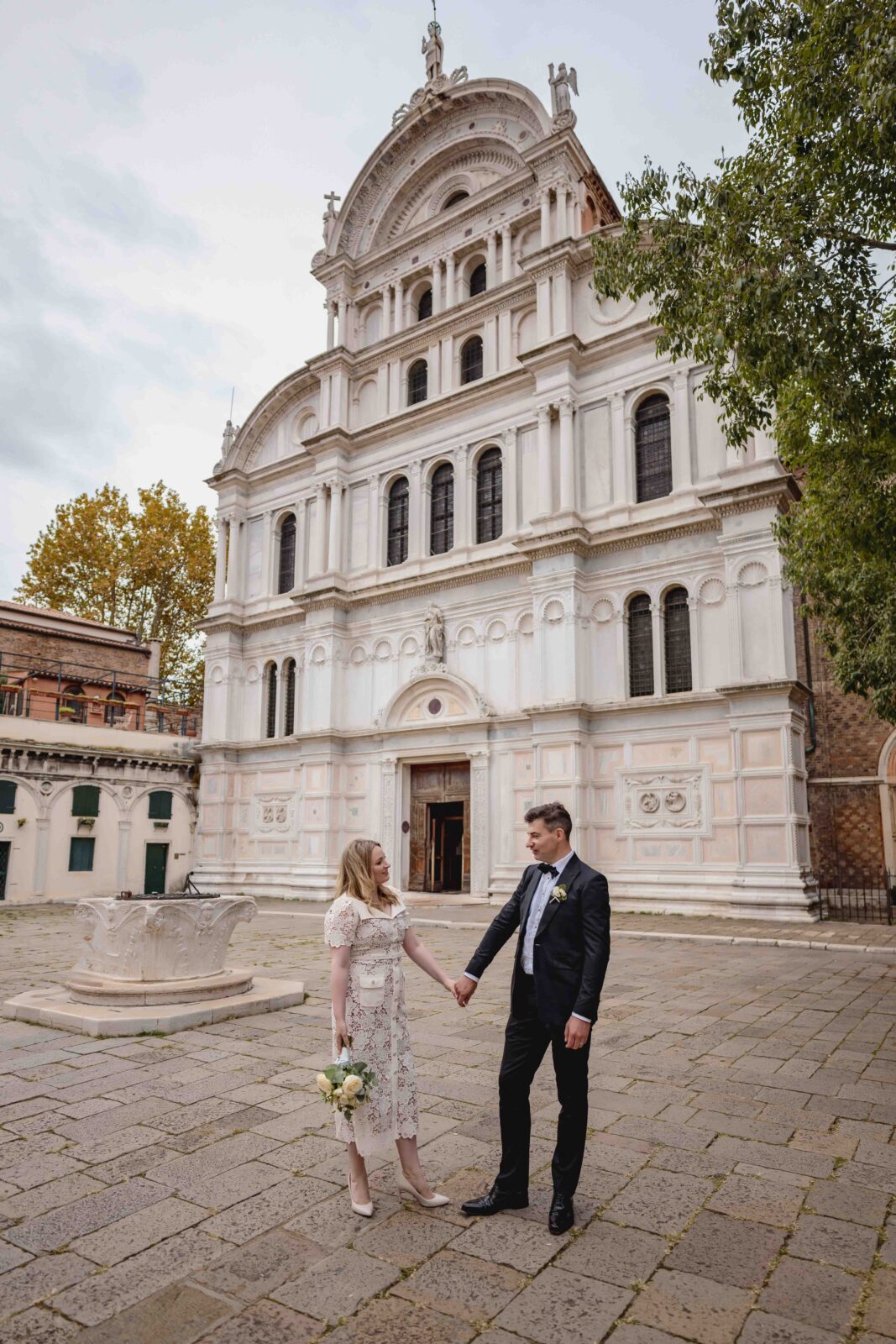 Venice church wedding ceremony with couple holding hands in front of historic Venetian church.