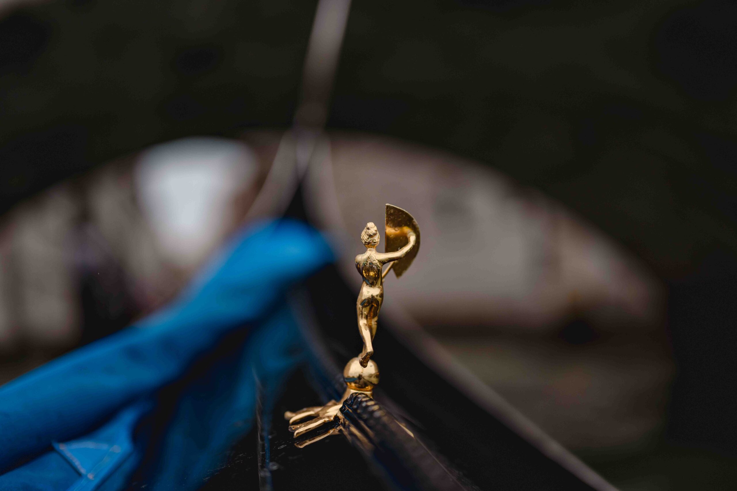 Venice church elopement, close-up of a gold wedding ring holder with a small statue, during a ceremony in Venice.