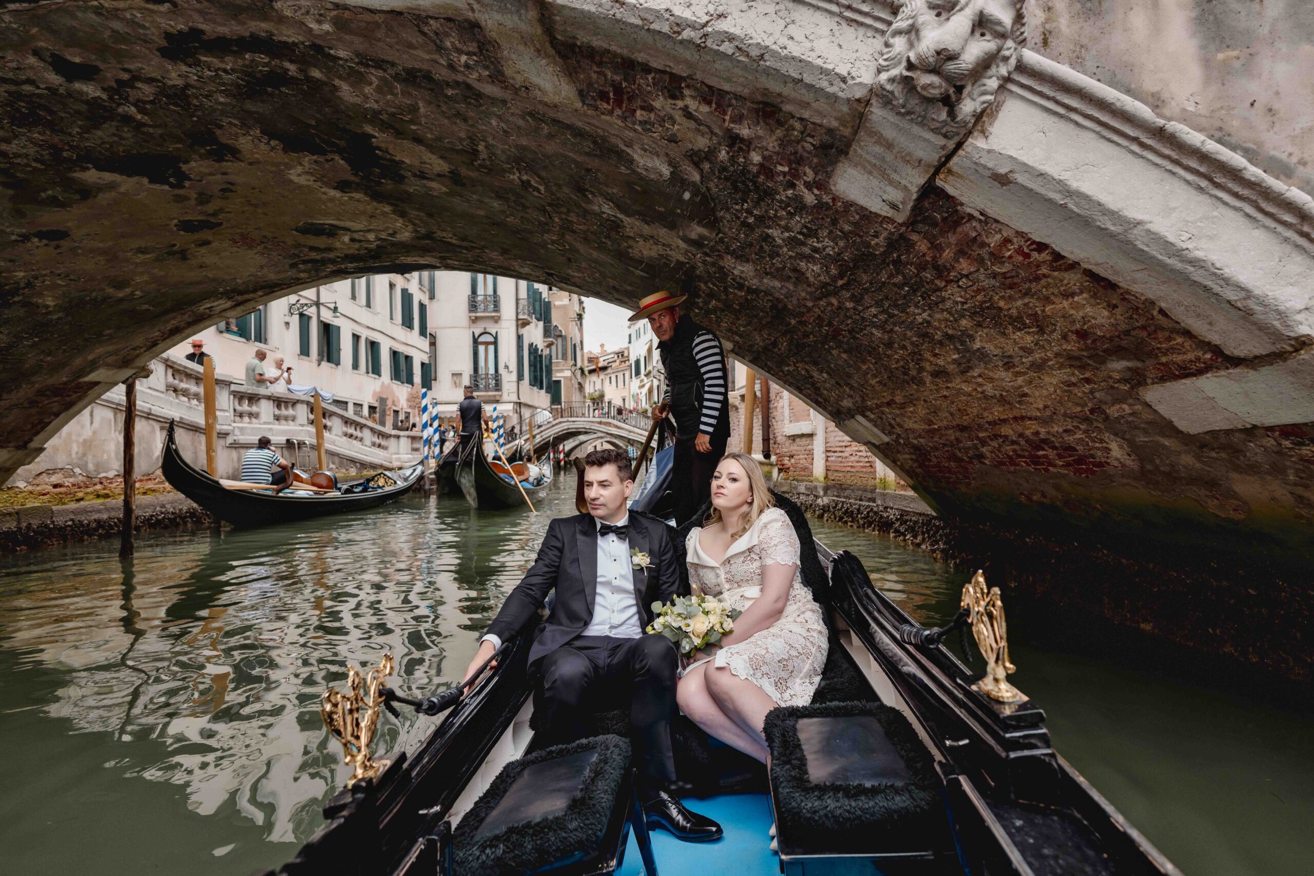 Venice, Italy, gondola ride under a historic bridge during a wedding elopement.