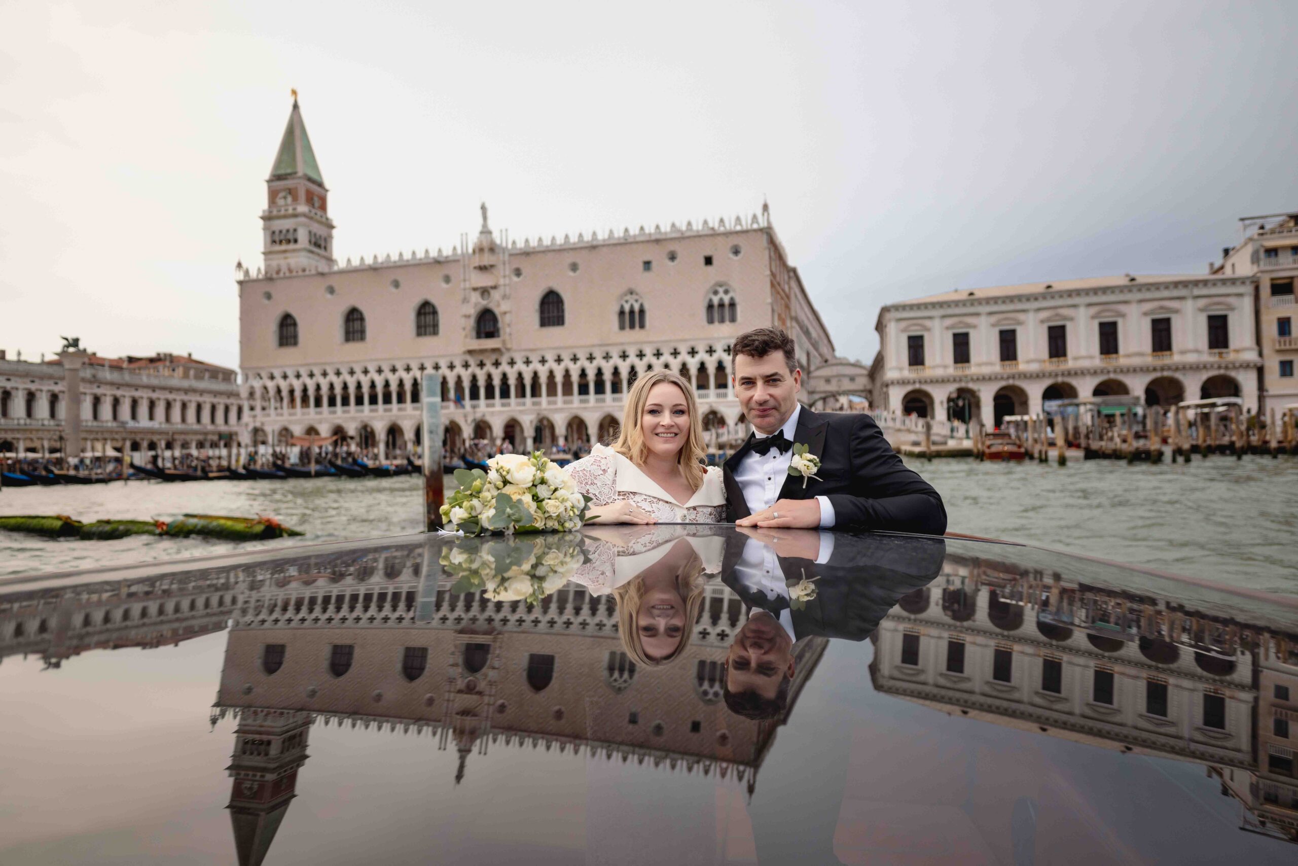 Venice, Italy - Elopement in a Venetian Church with a couple in wedding attire reflected on water.