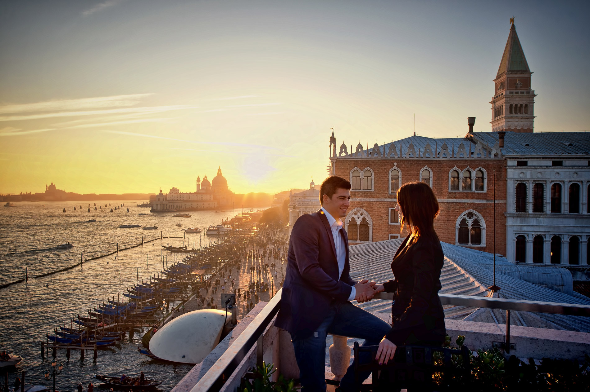 Couple standing together at sunset on the San Giorgio Maggiore waterfront, warm golden silhouette light, romantic moment during Venice proposal photography session
