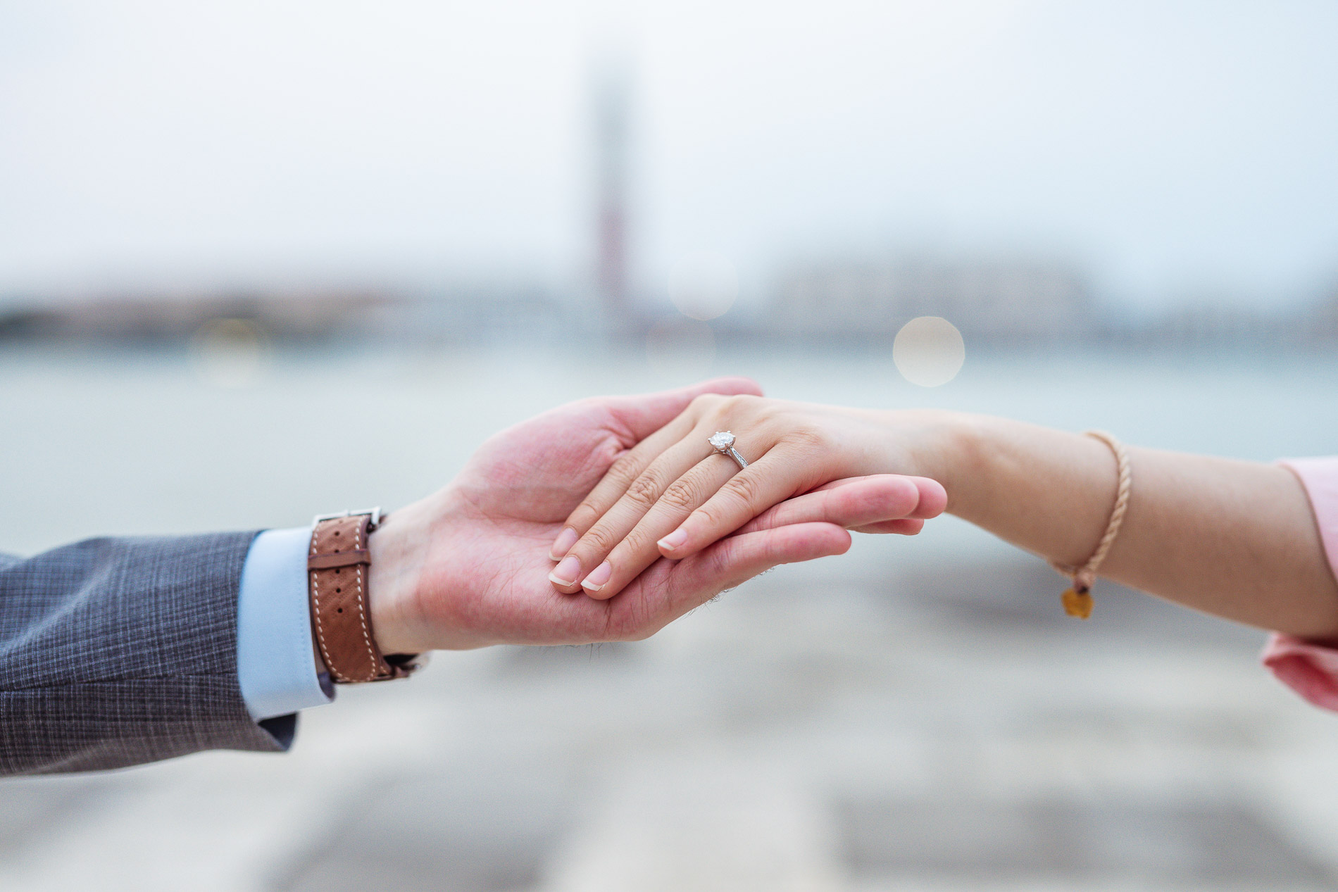 Close-up of a couple's hands showing an engagement ring, shallow depth of field, intimate detail shot during Venice proposal photography session at San Giorgio Maggiore