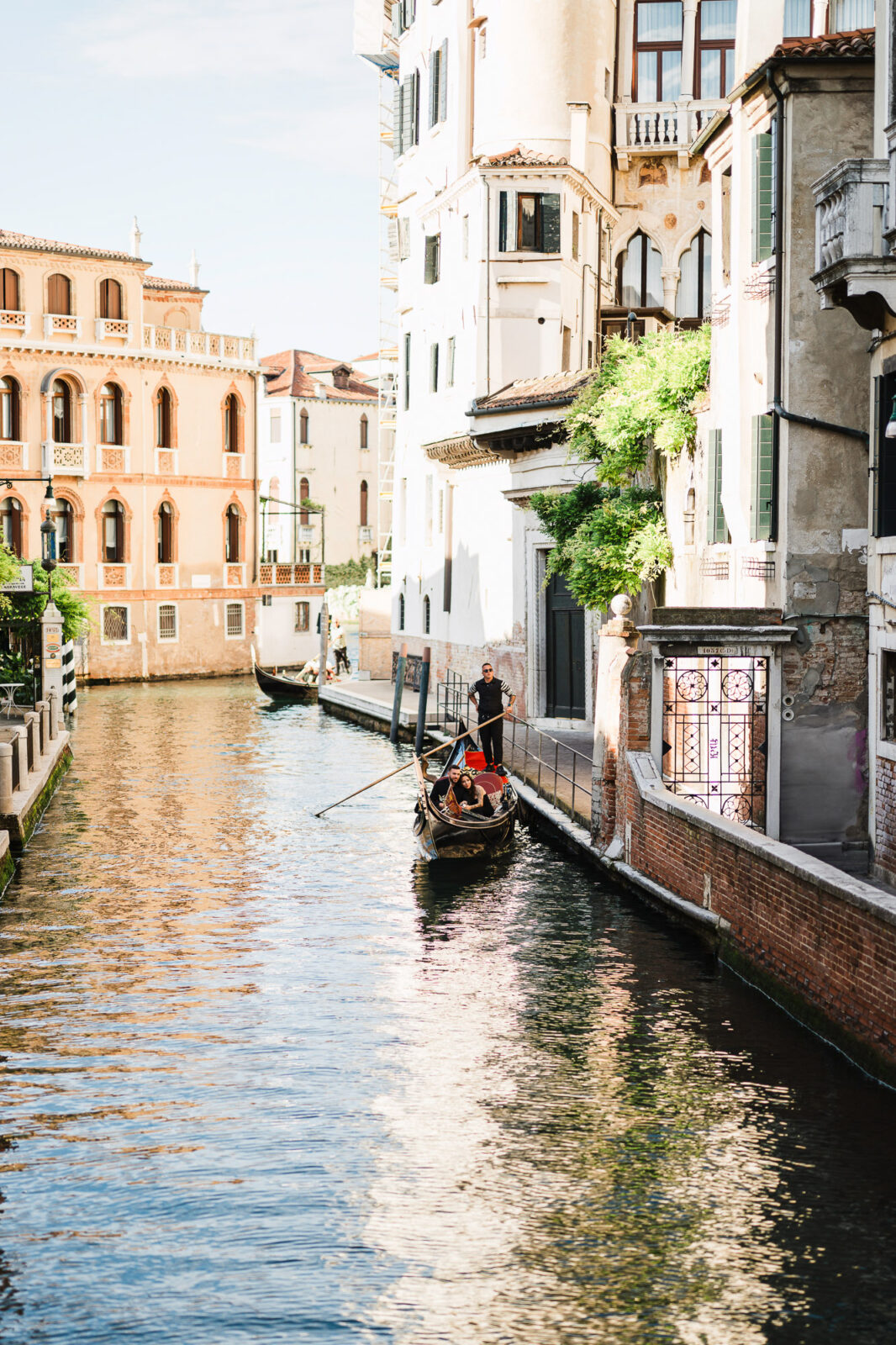 Gondola navigating Venice canal with historic buildings in the background.