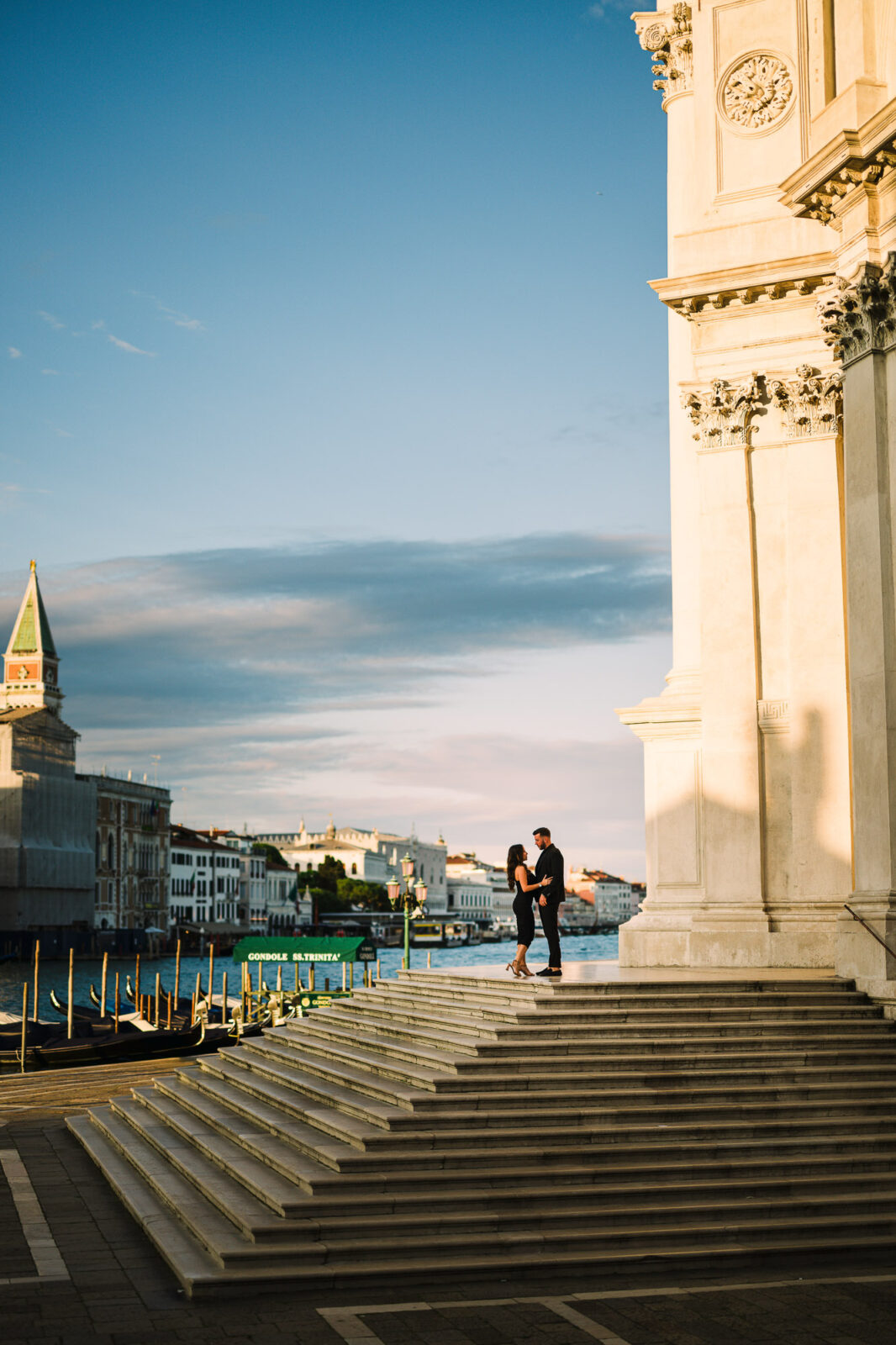 Romantic couple proposing on Venice steps near historic architecture and canal.