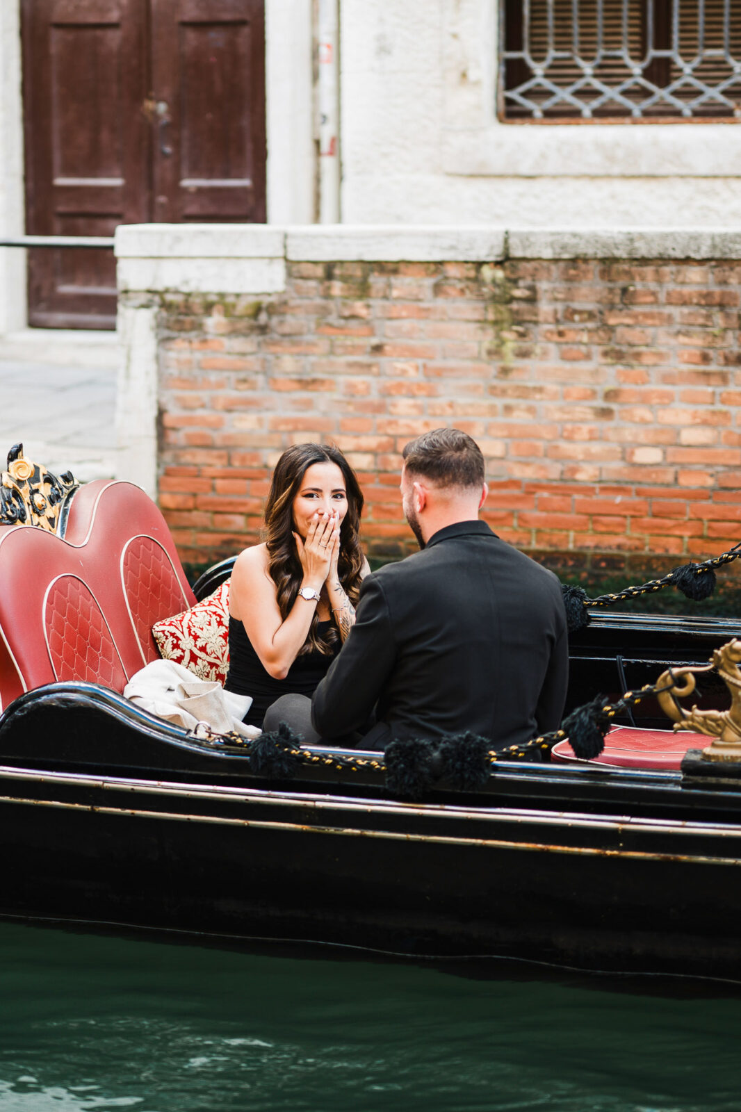 Romantic couple on a Venice gondola during a surprise proposal.