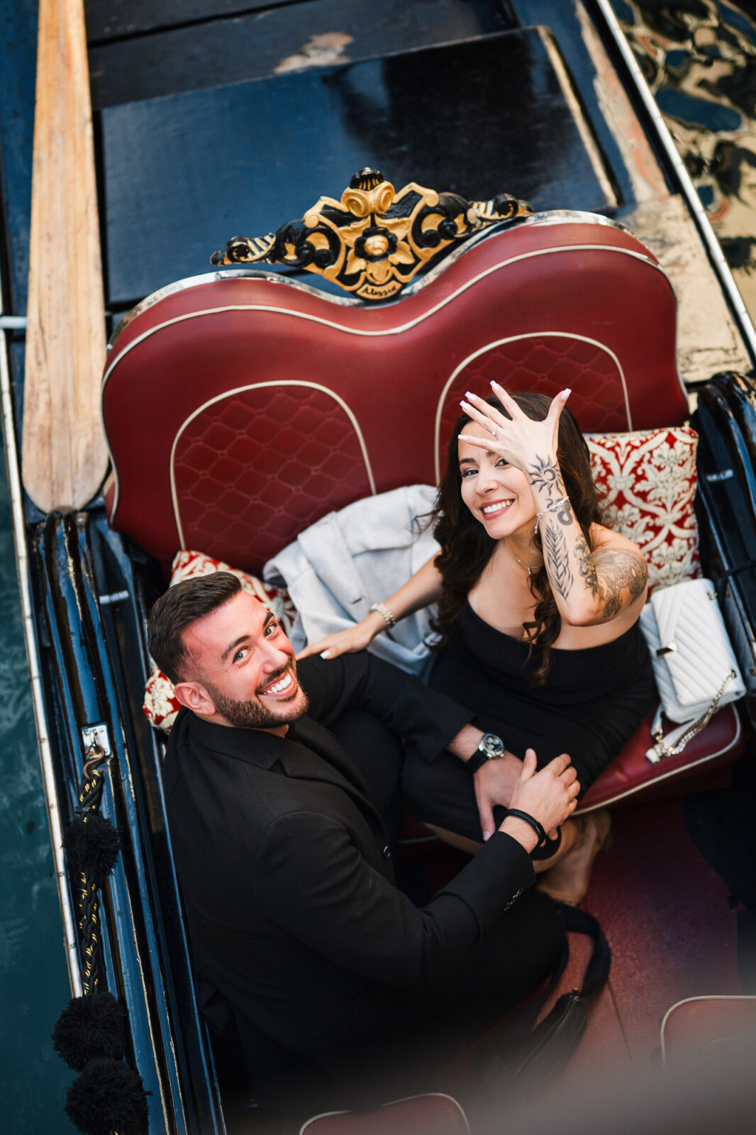 Romantic couple enjoying a gondola ride in Venice with a decorated boat interior.