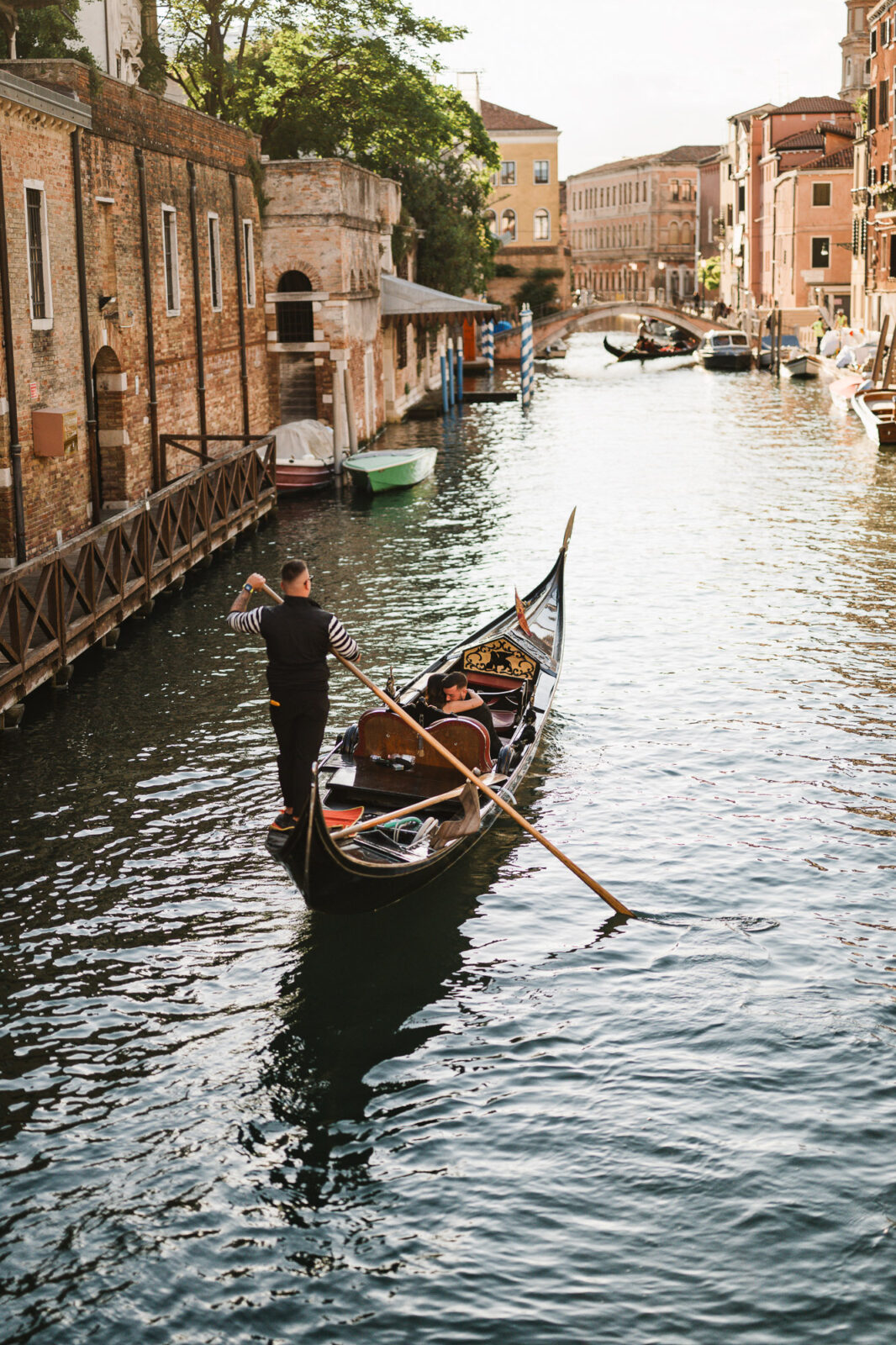 Romantic gondola ride through Venice canals with historic buildings in the background.