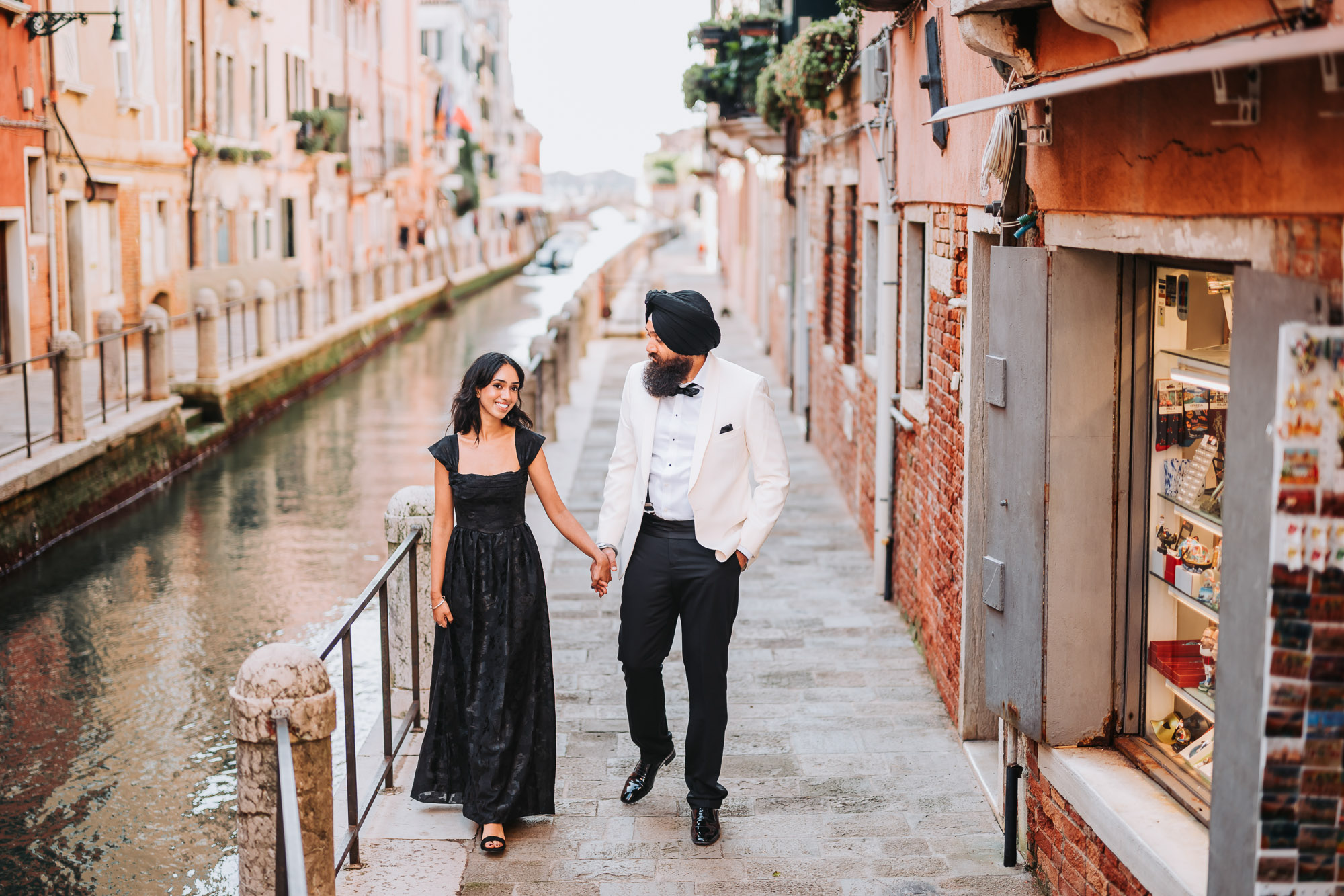 honeymoon couple walking along romantic Venetian canal street
