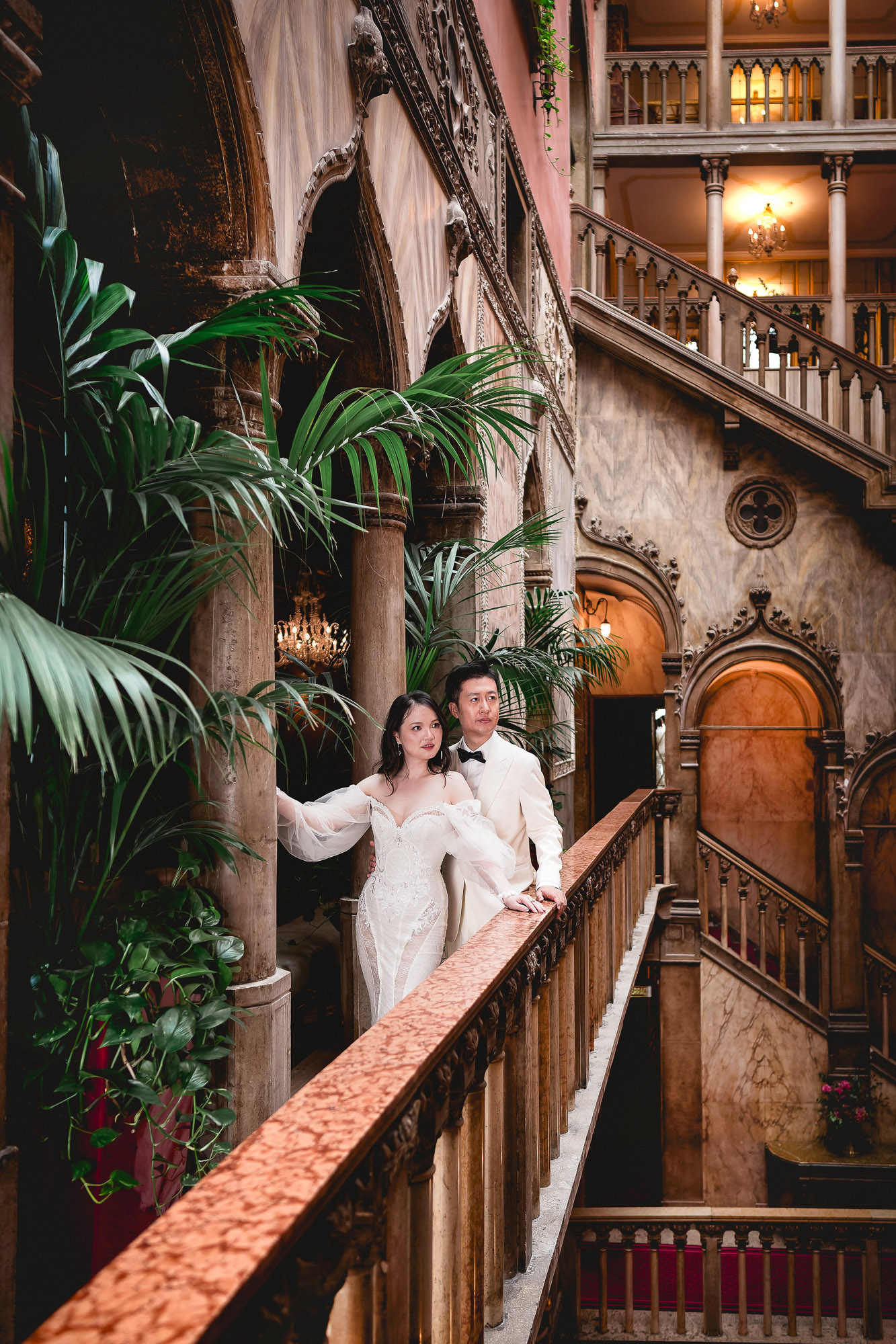 honeymoon couple on romantic Venetian staircase with tropical courtyard