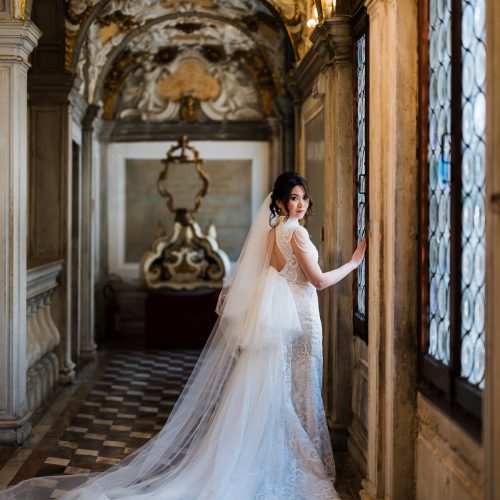 Venice Elopement Photo Story-89 Elegant woman in a lace dress with a long veil inside the ornate Scuola Grande dei Carmini.