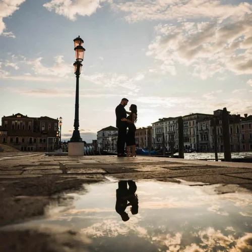 best-places-to-propose-in-venice (12) Couple embracing by water reflection.