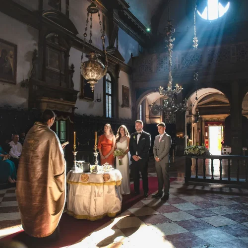 plan-your-wedding-in-venice-church (2) Elegant couple's wedding ceremony inside a historic Venice church with sunlight streaming through the window.